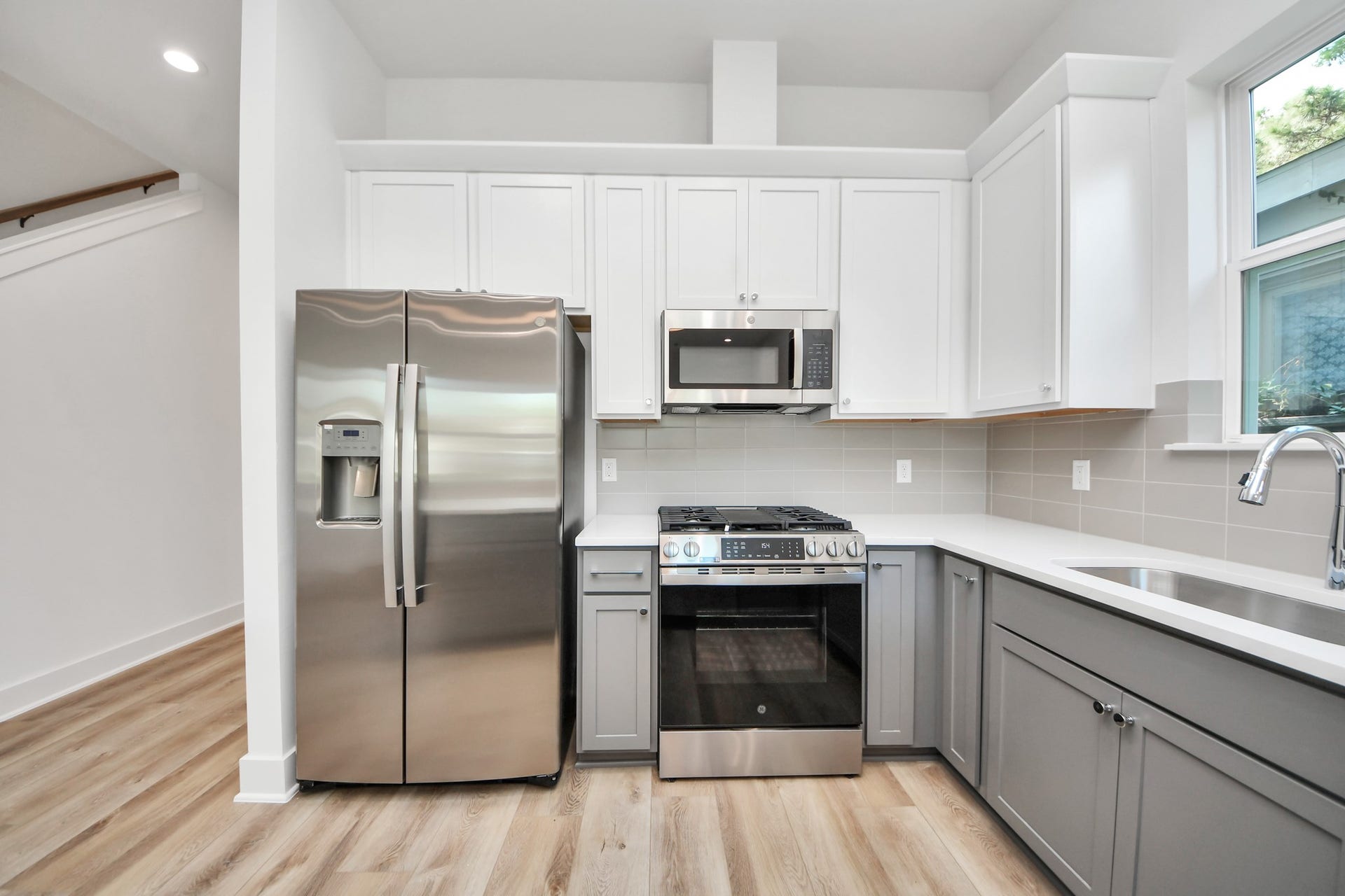 2904 Ruth Street, Houston, TX 77004 Unit A kitchen featuring white cabinetry, gray lower cabinets, and stainless steel appliances.