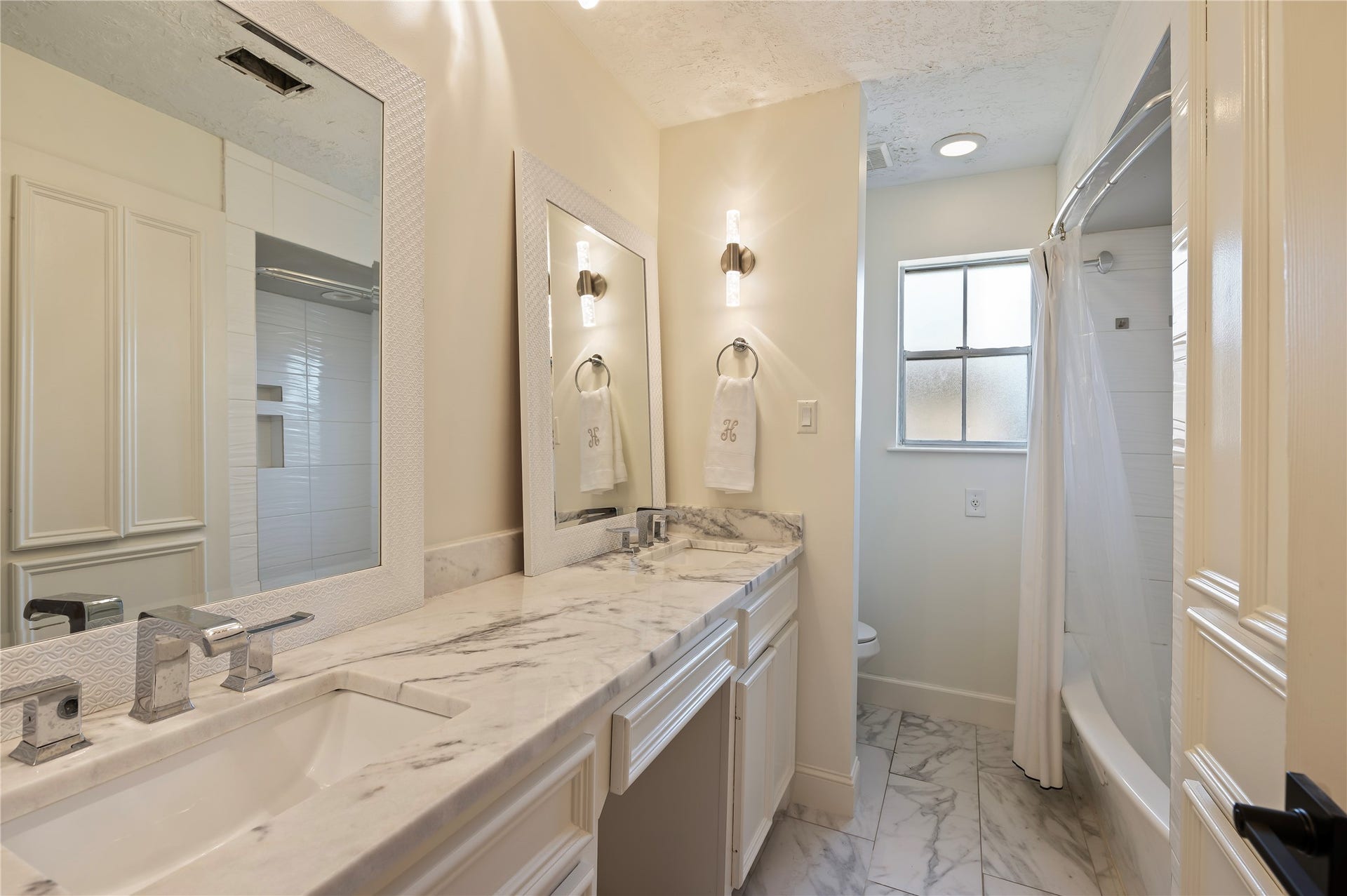 501 Audubon Street, League City, TX 77573 Full sized secondary bath with his/her vanities, large vanity mirror, tile flooring and more.
