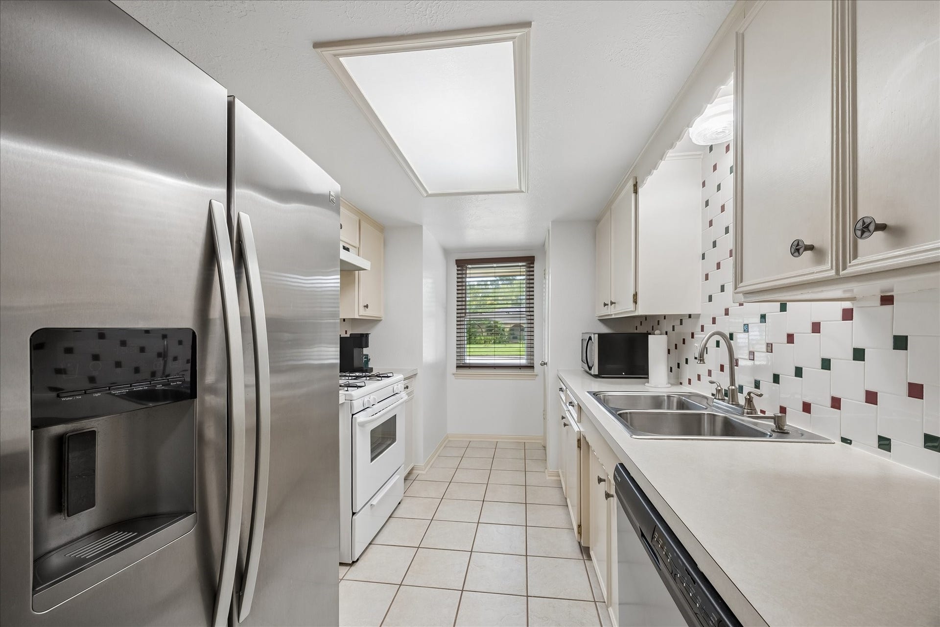 13626 Greenridge Drive, Sugar Land, TX 77498 Bright and functional kitchen featuring stainless steel appliances, ample cabinetry, and a scenic window view.