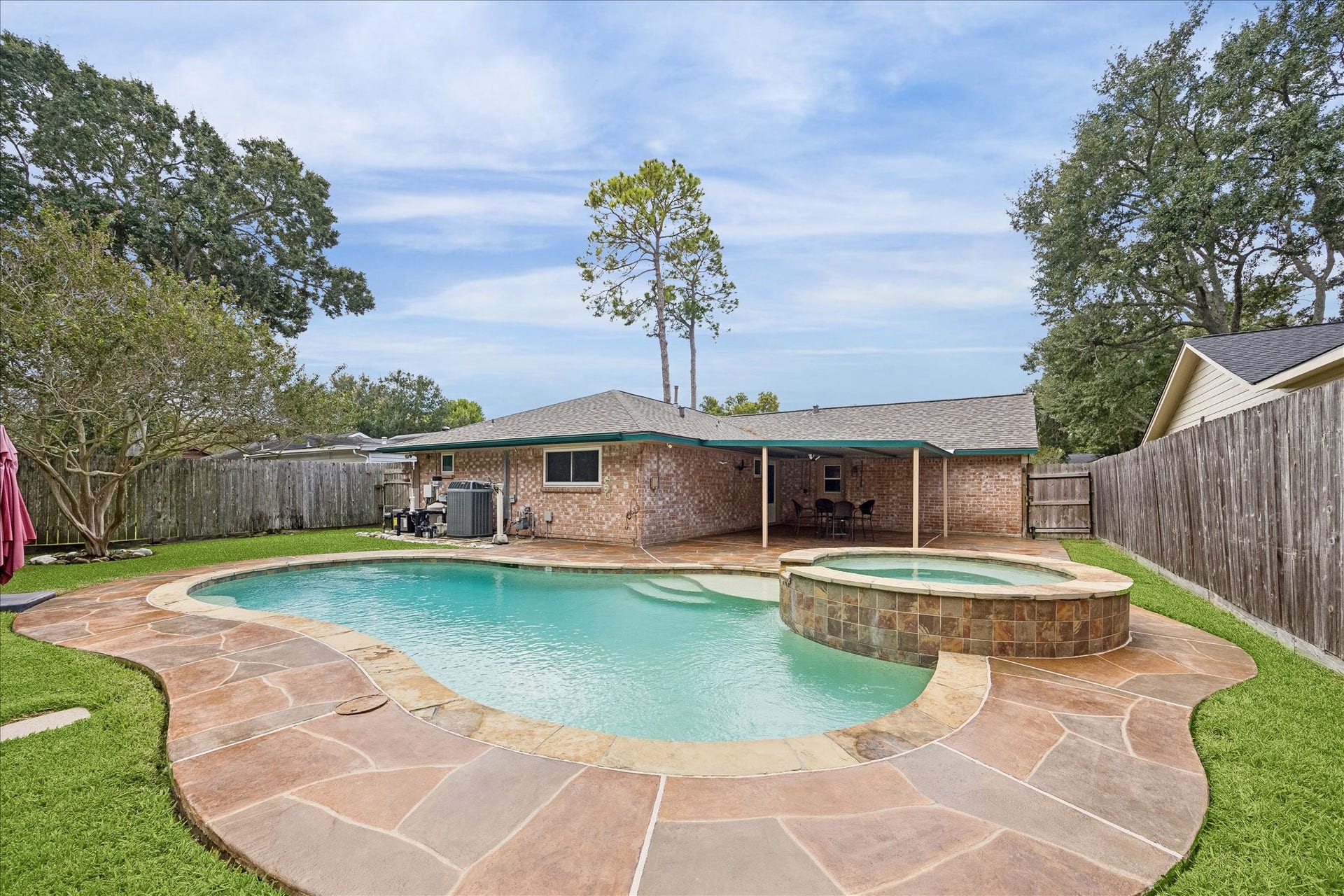 13626 Greenridge Drive, Sugar Land, TX 77498 Experience outdoor relaxation in this backyard oasis featuring a sparkling pool and spa, complemented by a spacious patio perfect for entertaining.