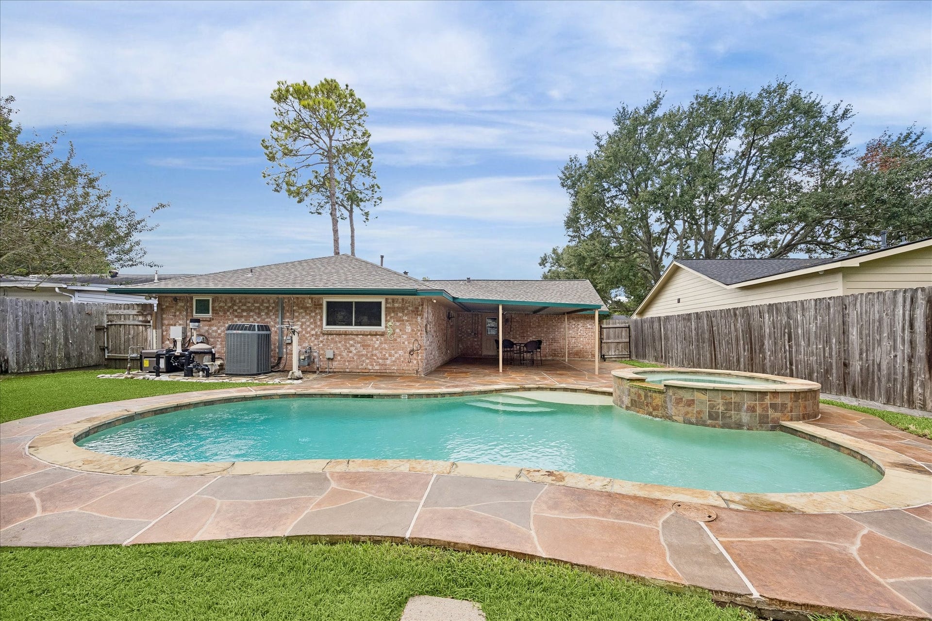 13626 Greenridge Drive, Sugar Land, TX 77498 Enjoy outdoor living with this spacious backyard featuring a sparkling pool and spa, surrounded by a beautiful stone patio and privacy fencing.