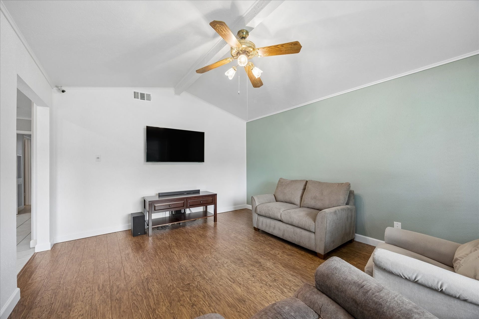 13626 Greenridge Drive, Sugar Land, TX 77498 Bright and inviting living room featuring a vaulted ceiling with a ceiling fan, warm wood flooring perfect for relaxation and entertainment.
