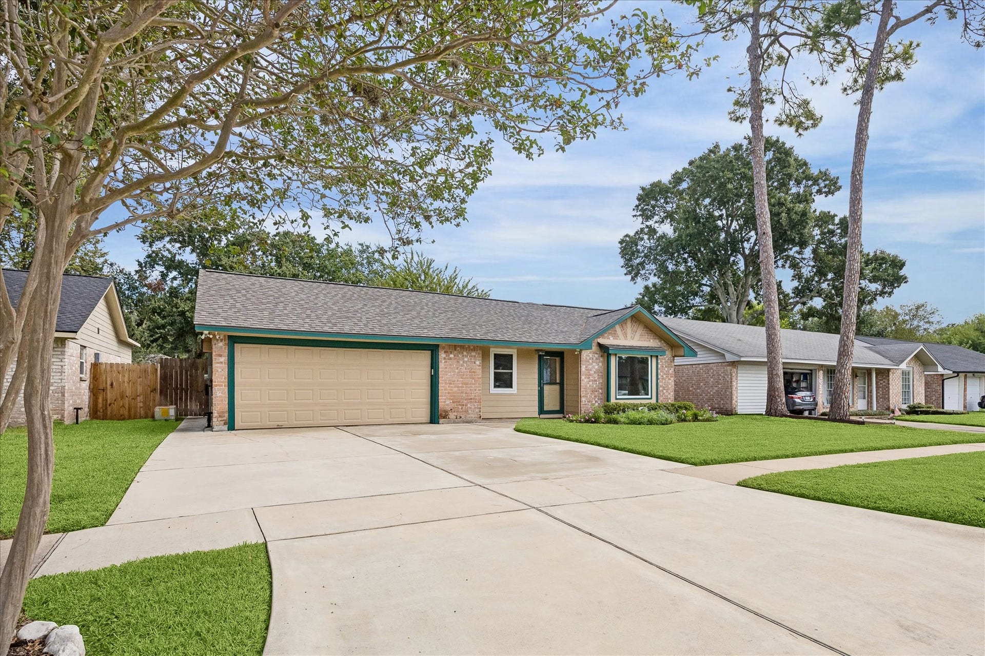 13626 Greenridge Drive, Sugar Land, TX 77498 Charming single-story brick home with a spacious driveway, attached two-car garage, and well-maintained front lawn.