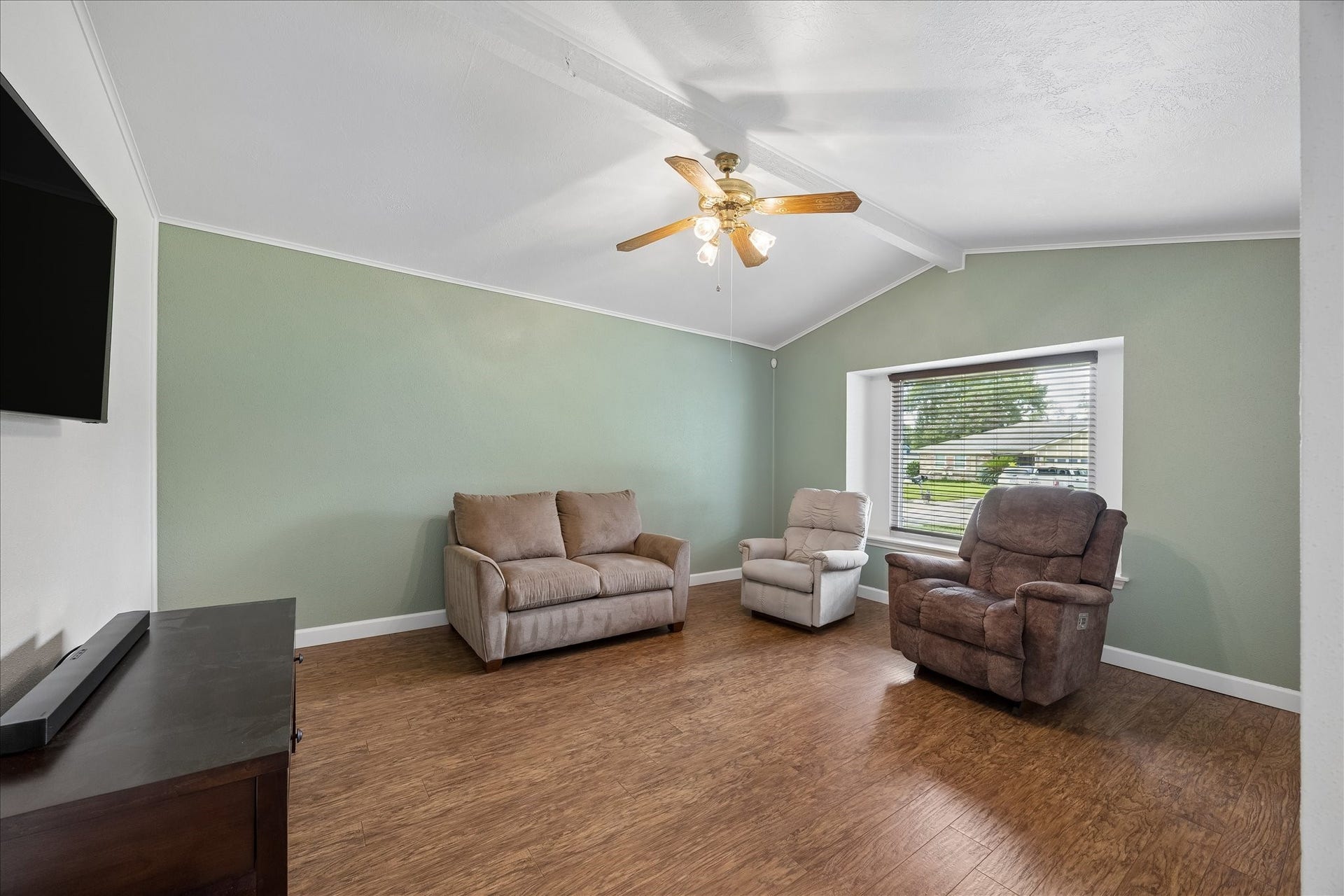 13626 Greenridge Drive, Sugar Land, TX 77498 Bright and inviting living room with vaulted ceiling, warm wood flooring, and a large window providing ample natural light.