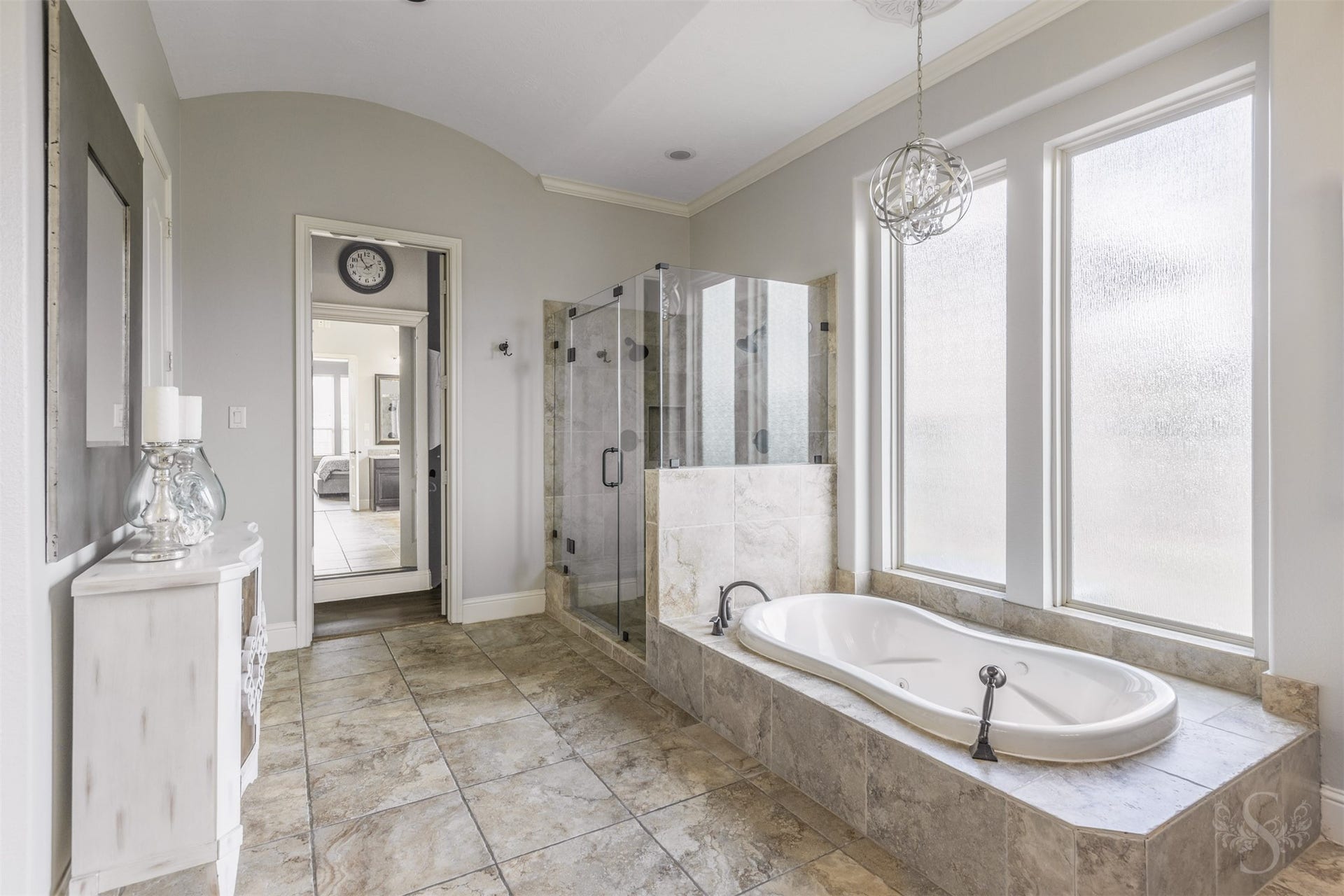5835 Caspian Falls Lane, Fulshear, TX 77441 Unwind in the luxurious primary bath featuring a soaking tub, oversized walk-in shower and beautiful natural light. The spacious layout creates a spa-like atmosphere designed for relaxation and comfort.