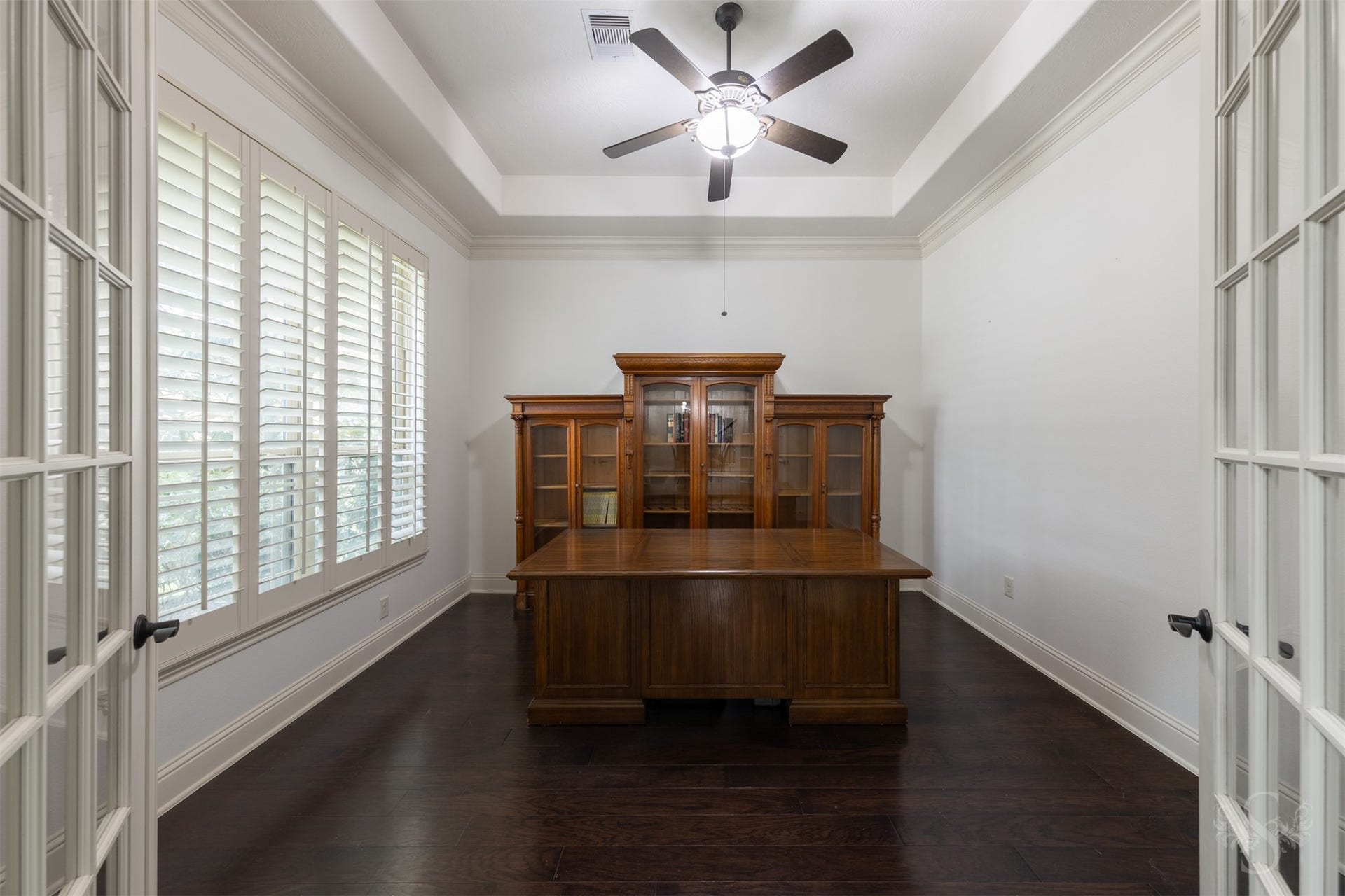 5835 Caspian Falls Lane, Fulshear, TX 77441 Tucked behind French doors, the private study offers a quiet and refined workspace ideal for working from home. Plantation shutters, wood flooring and a tray ceiling enhance the room's elegant design while creating a comfortable place to focus and be productive.