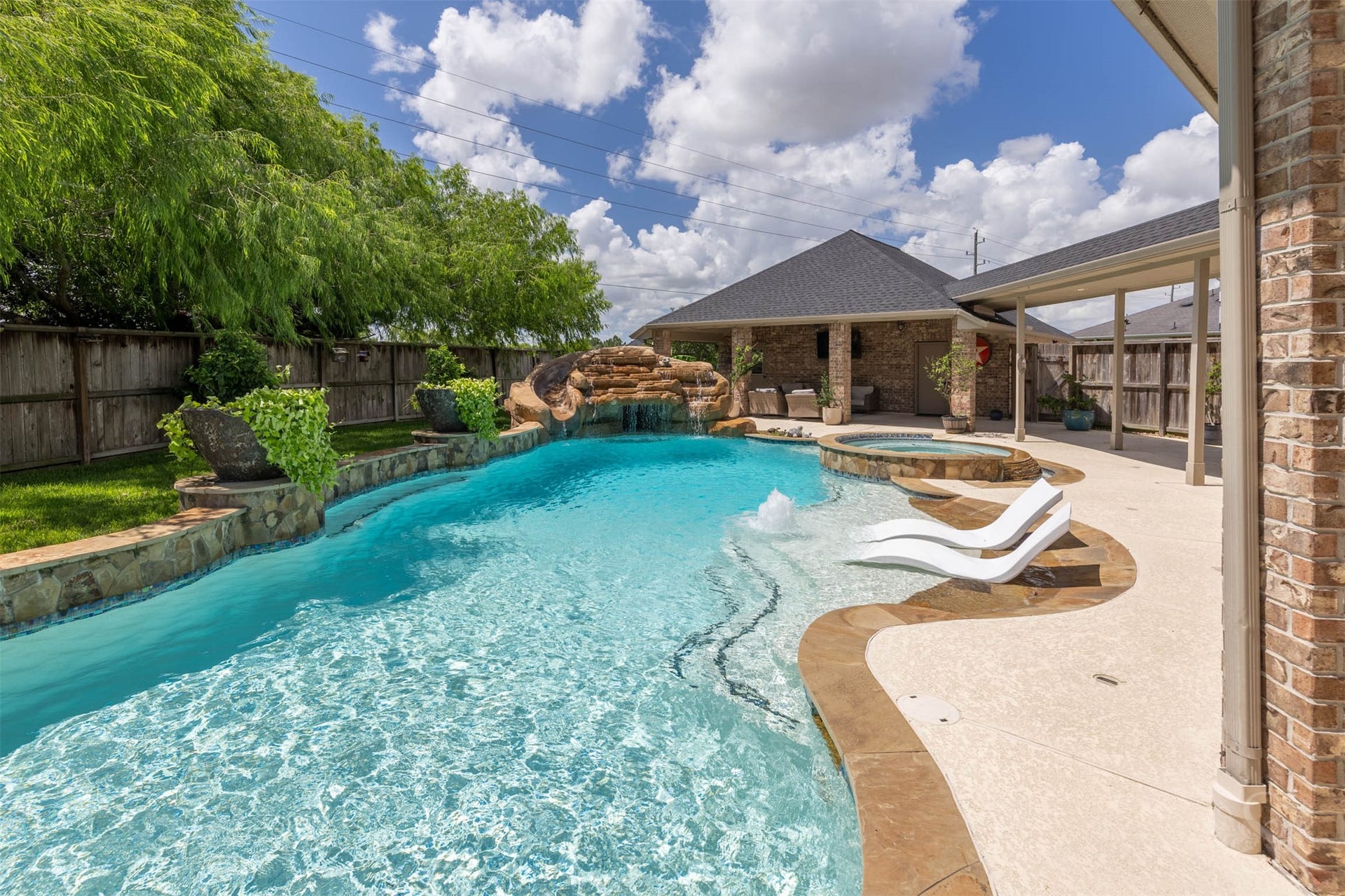 5835 Caspian Falls Lane, Fulshear, TX 77441 Lounge in the sun on the oversized tanning ledge while enjoying views of the waterfall, spa and beautifully landscaped surroundings. The generous pool deck offers ample space for outdoor entertaining.