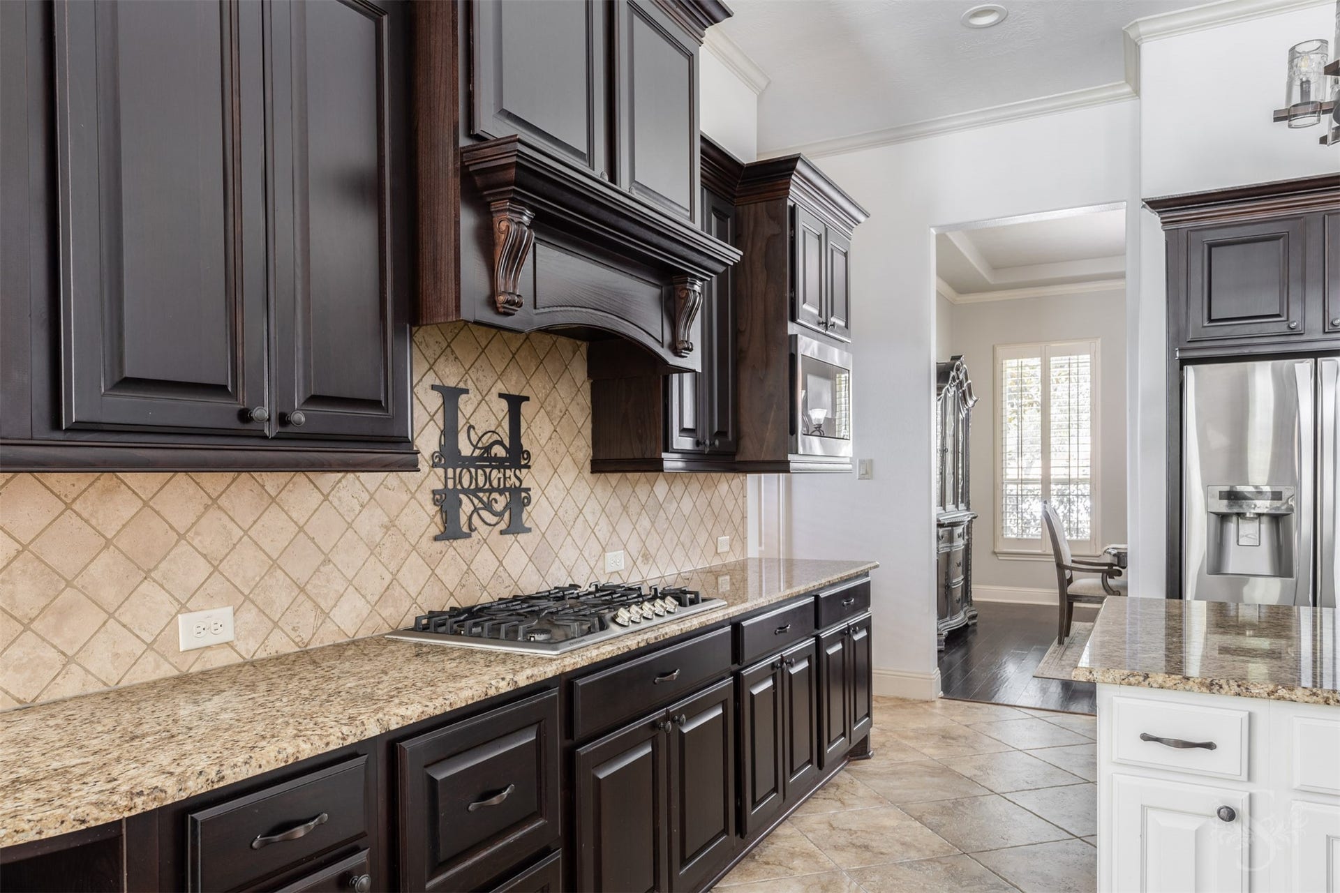 5835 Caspian Falls Lane, Fulshear, TX 77441 Rich cabinetry, detailed millwork and granite surfaces create a warm and inviting atmosphere in the heart of the home. The gas cooktop and extensive counter space make this kitchen as practical as it is beautiful.