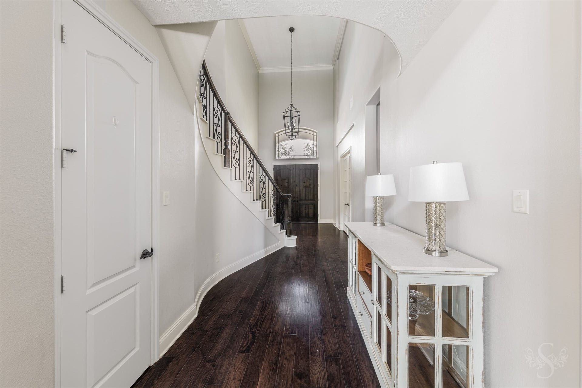 5835 Caspian Falls Lane, Fulshear, TX 77441 Rich wood flooring, soaring ceilings and graceful architectural details create a warm and inviting arrival experience. The hallway draws your eye toward the impressive front entry and showcases the home's thoughtful design.