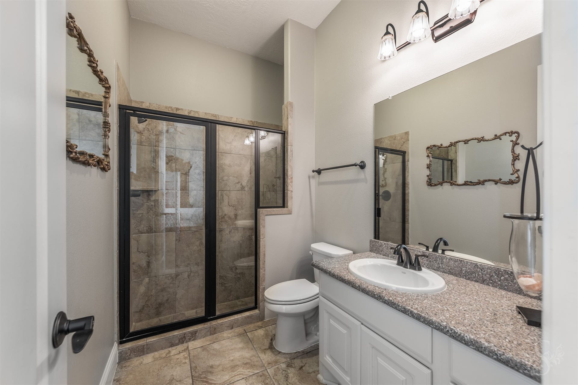 5835 Caspian Falls Lane, Fulshear, TX 77441 Serving the first-floor secondary bedroom, this well-appointed full bath features granite countertops, a walk-in shower and timeless finishes. The private layout makes it an excellent setup for overnight guests or extended family.