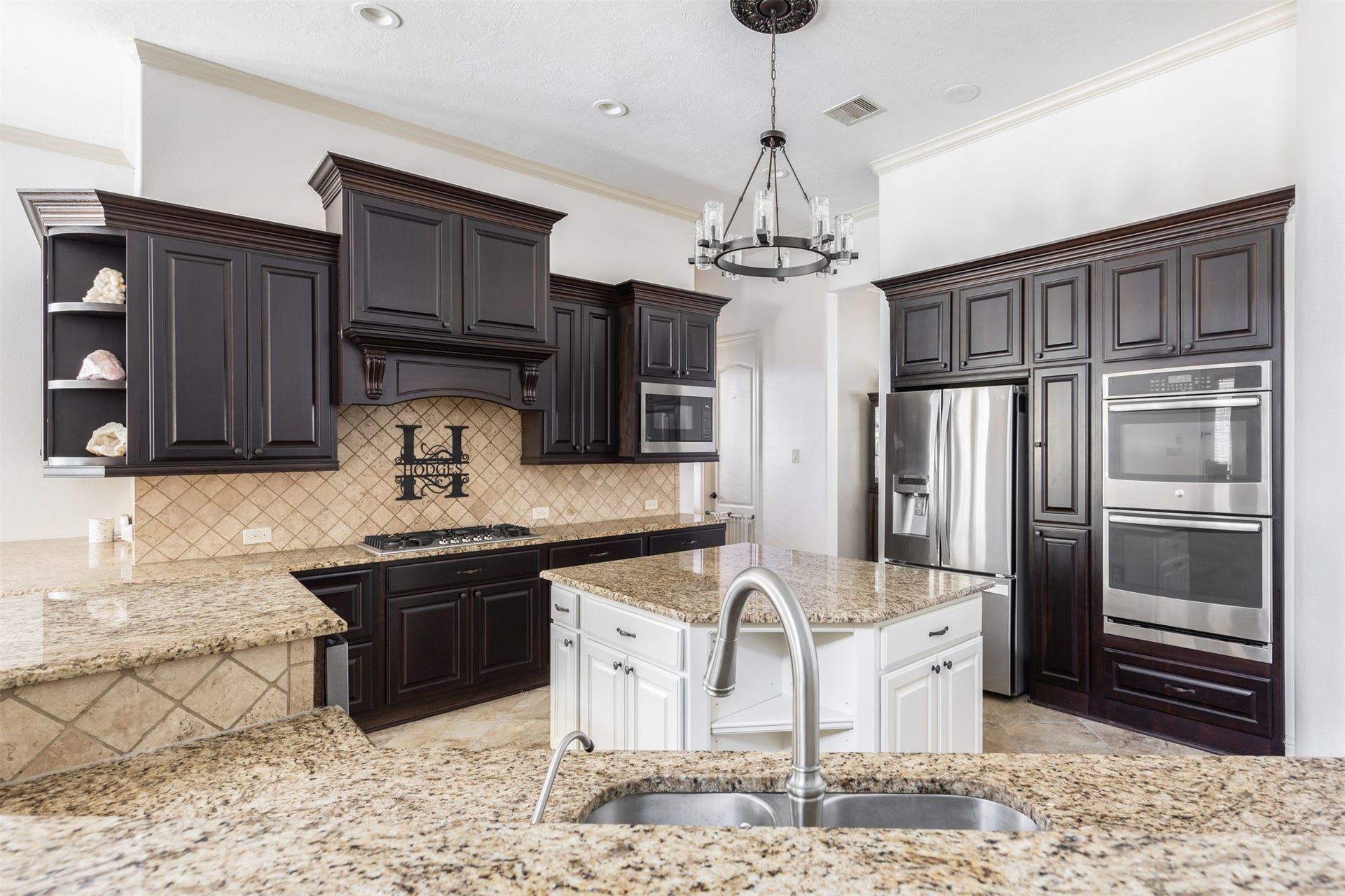 5835 Caspian Falls Lane, Fulshear, TX 77441 Designed for the home chef, this impressive kitchen features abundant cabinetry, granite countertops, stainless steel appliances, double ovens and a center island. The open-concept layout keeps everyone connected while providing ample space for meal preparation and entertaining.