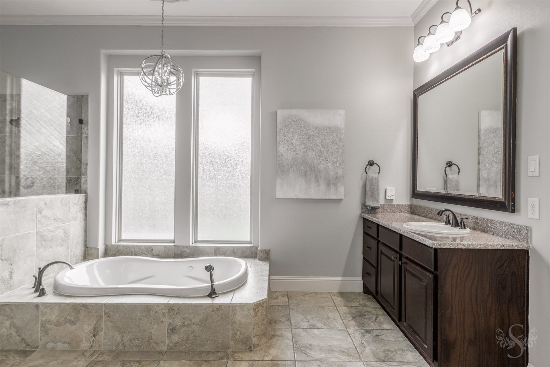 5835 Caspian Falls Lane, Fulshear, TX 77441 Start and end each day in this elegant primary bath complete with dual vanities, a soaking tub and an oversized walk-in shower. Large windows fill the space with soft natural light, enhancing the bright and airy feel.