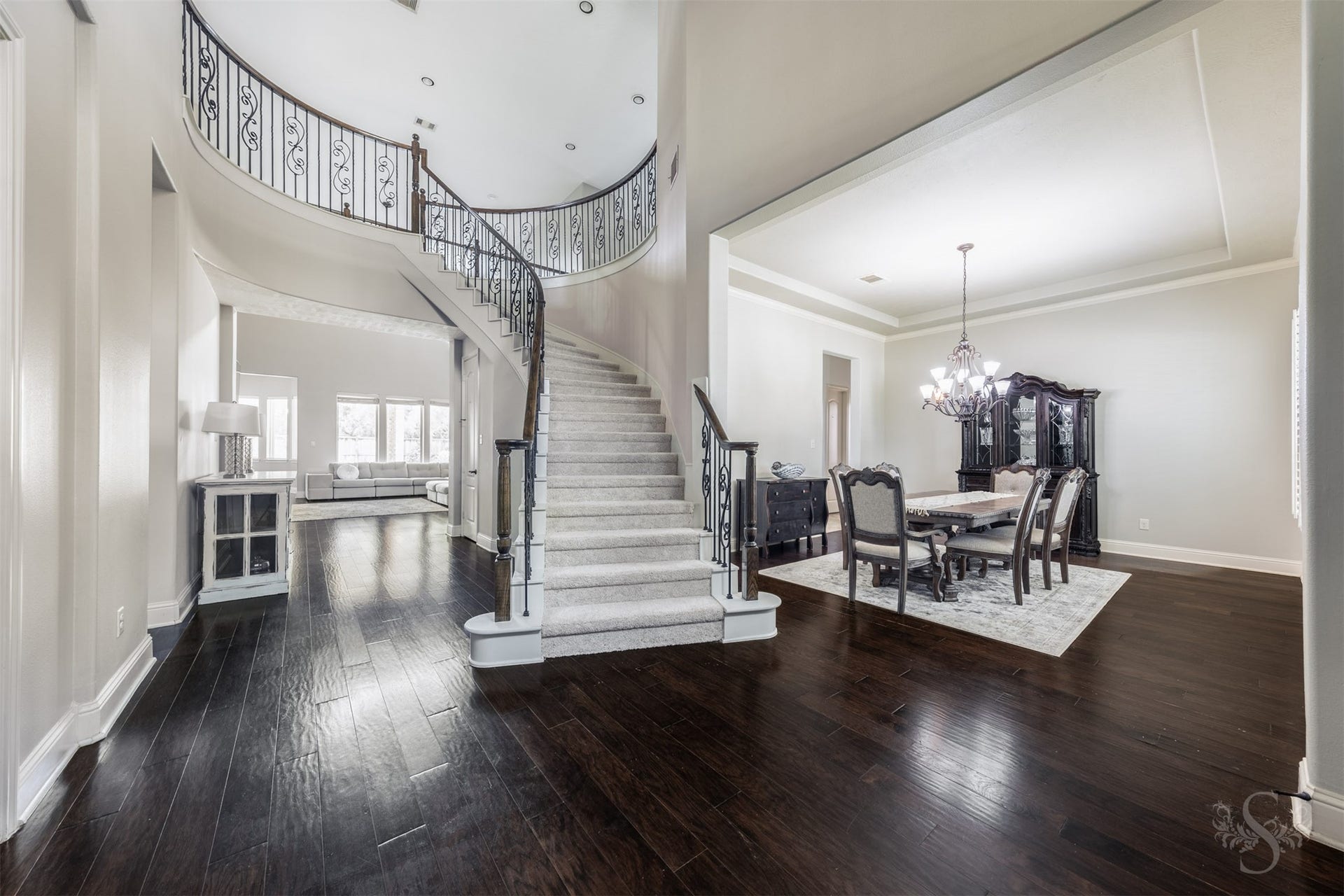 5835 Caspian Falls Lane, Fulshear, TX 77441 A grand 2 story entry creates a stunning first impression with rich wood flooring, a curved staircase with iron balusters and elegant architectural detailing throughout. The formal dining room provides a beautiful setting for holiday gatherings, dinner parties and special occasions.