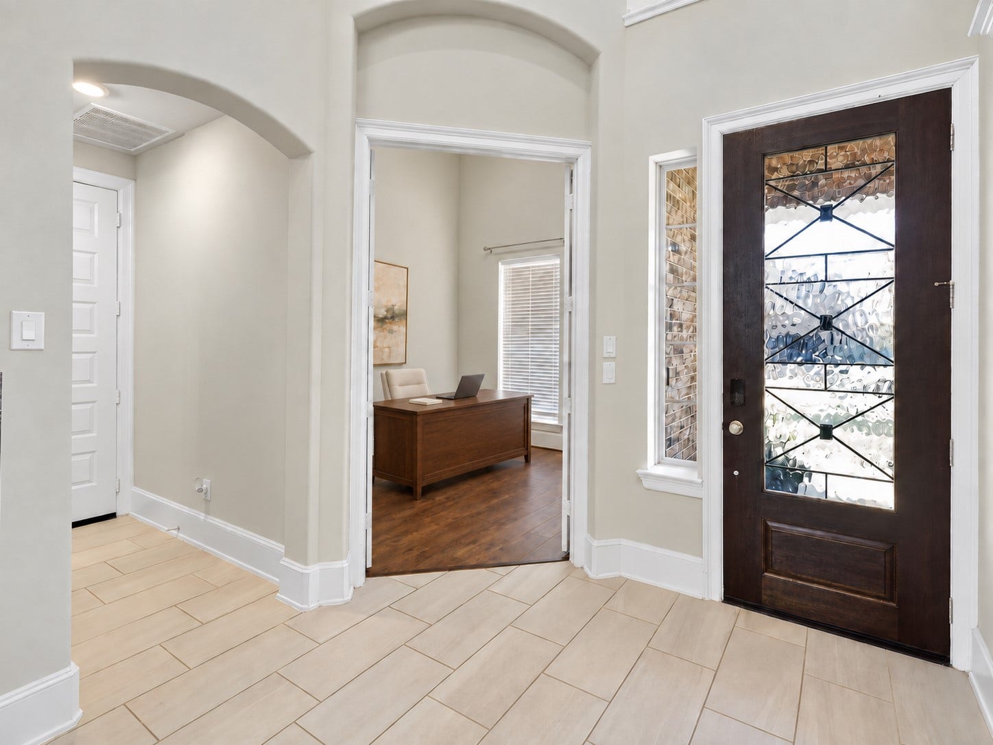 6714 Wellbrook Falls Lane, Katy, TX 77493 Foyer features a decorative glass front door and arched architectural details. (virtually staged)