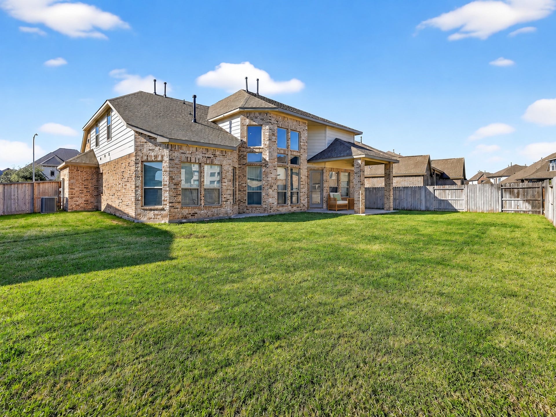 6714 Wellbrook Falls Lane, Katy, TX 77493 Spacious fenced backyard offers an open lawn and covered patio. (virtually staged)