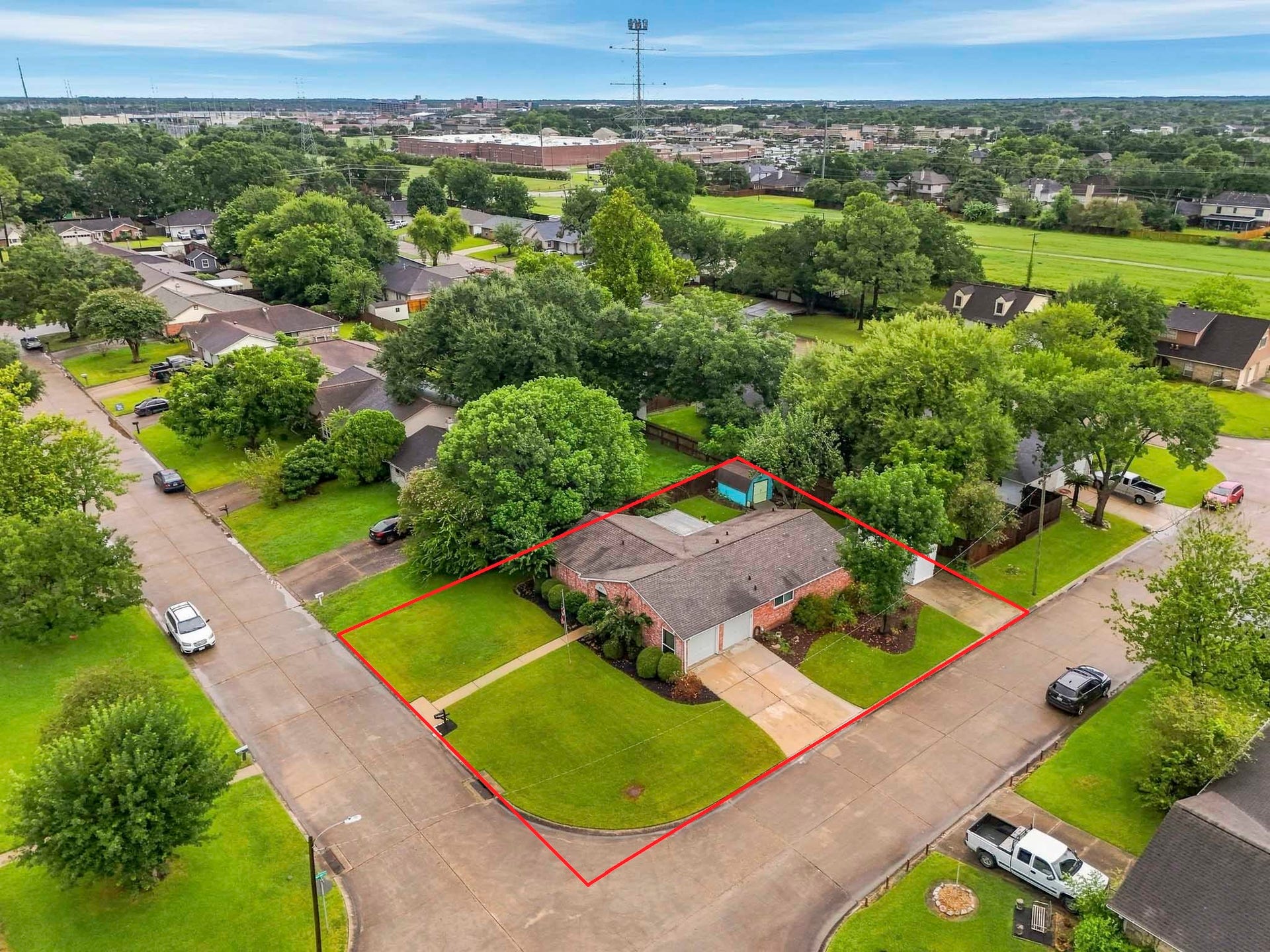 Aerial view showcases the homes spacious corner lot with mature trees in the established Newport neighborhood. Property lines have been estimated.