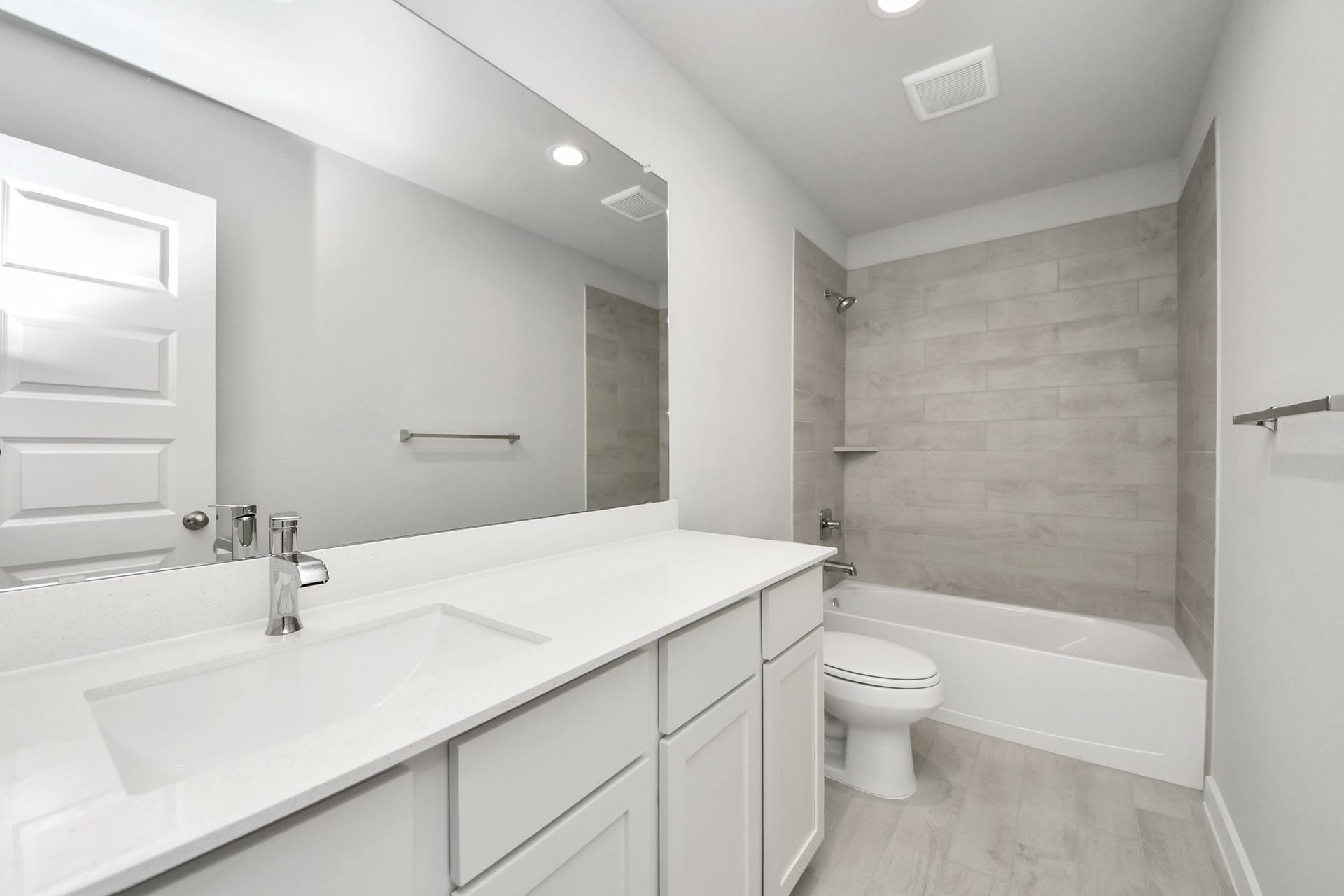 11023 Hosta Stream Drive, Houston, TX 77044 Secondary bath features tile flooring, bath/shower combo with tile surround, light stained wood cabinets, beautiful light countertop. Sample photo of completed home with similar floor plan. Actual colors and selections may vary.