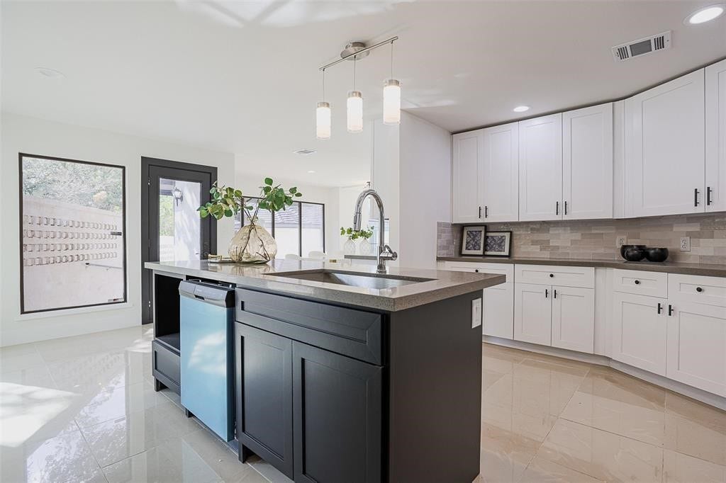 5614 Indian Circle, Houston, TX 77056 Striking black island with a sleek gray quartz countertop and integrated sink, creating a bold focal point in the kitchen. The combination of dark and light tones adds sophistication, complementing the overall design with both functionality and style.