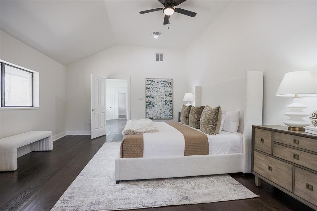 5614 Indian Circle, Houston, TX 77056 Luxurious primary suite featuring soaring ceilings and rich dark brown engineered wood flooring that adds warmth and sophistication. The suite includes an elegant ensuite bathroom and a spacious walk-in closet, offering both comfort and style in a private, tranquil retreat.