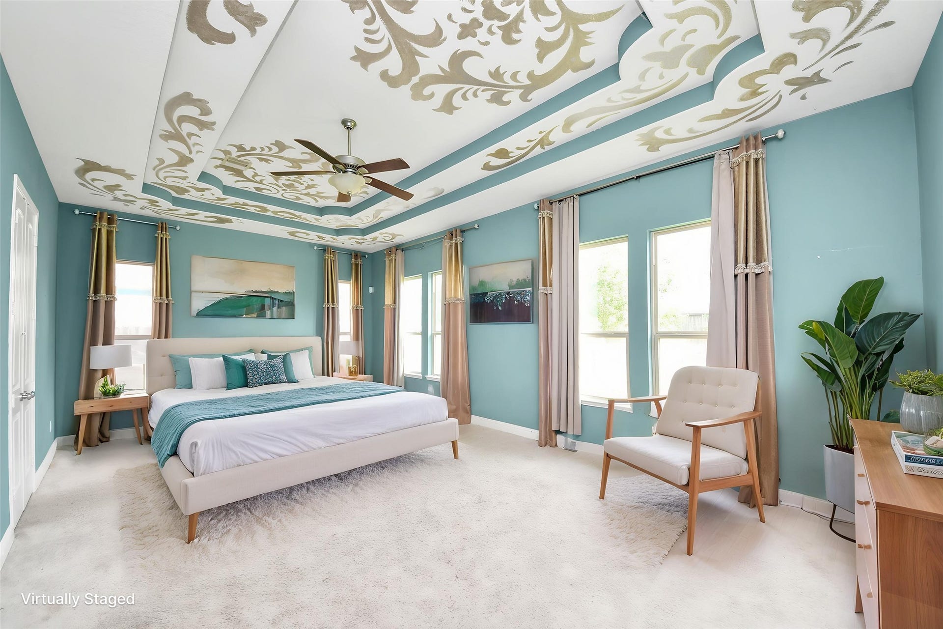 Spacious primary retreat with abundant natural light, multiple windows, and a dramatic custom-designed tray ceiling. Virtually staged.