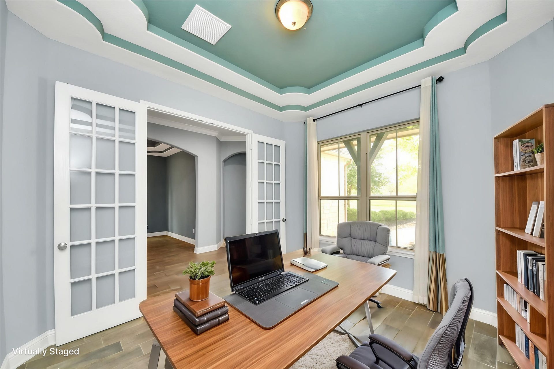 Virtually Staged  Dedicated home office with French doors, decorative ceiling detail, large window, and virtual staging.