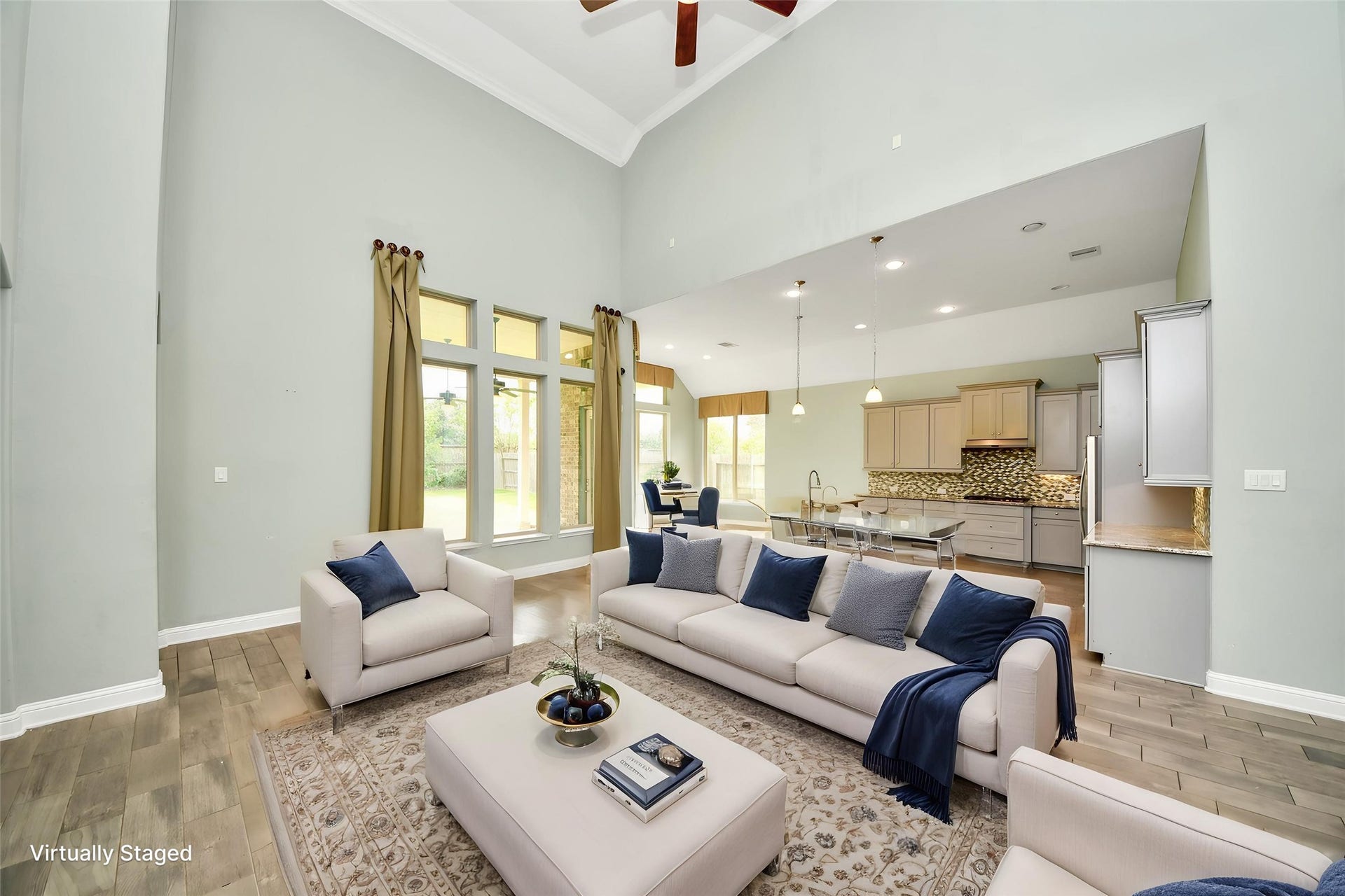 Virtually Staged  Open-concept living area flows seamlessly into the kitchen, highlighted by soaring ceilings and abundant natural light.