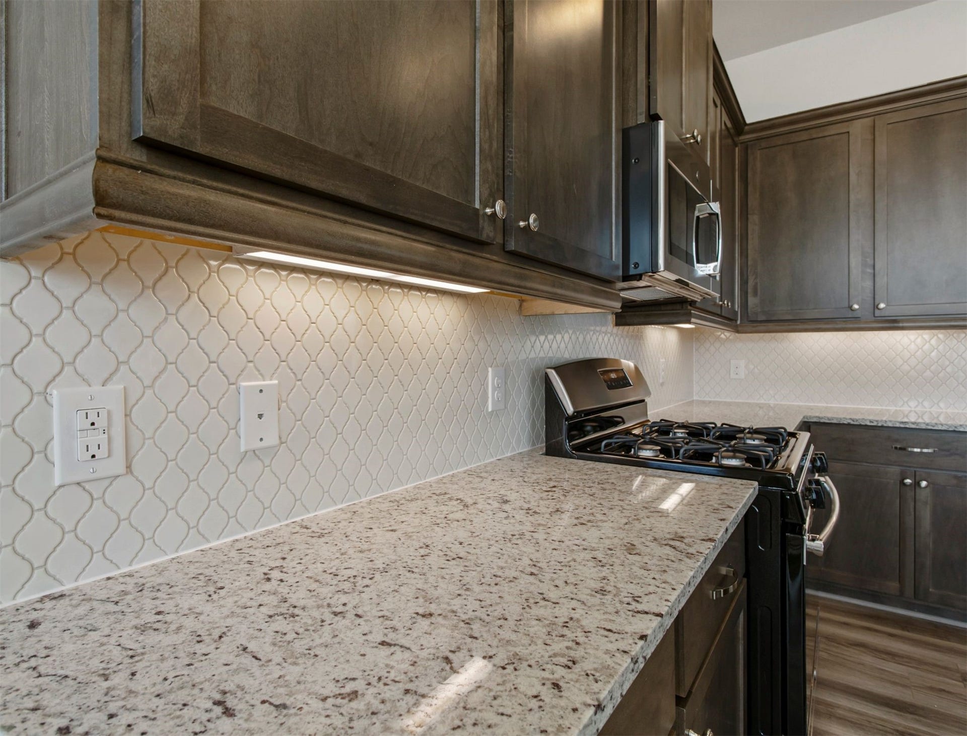 2511 Bordelon Lane, Missouri City, TX 77459 The subtle design choices in this home are perfect. Take note of this elegant lantern print tile backsplash, granite countertop, under cabinet lighting, and numerous conveniently placed wall plugs.