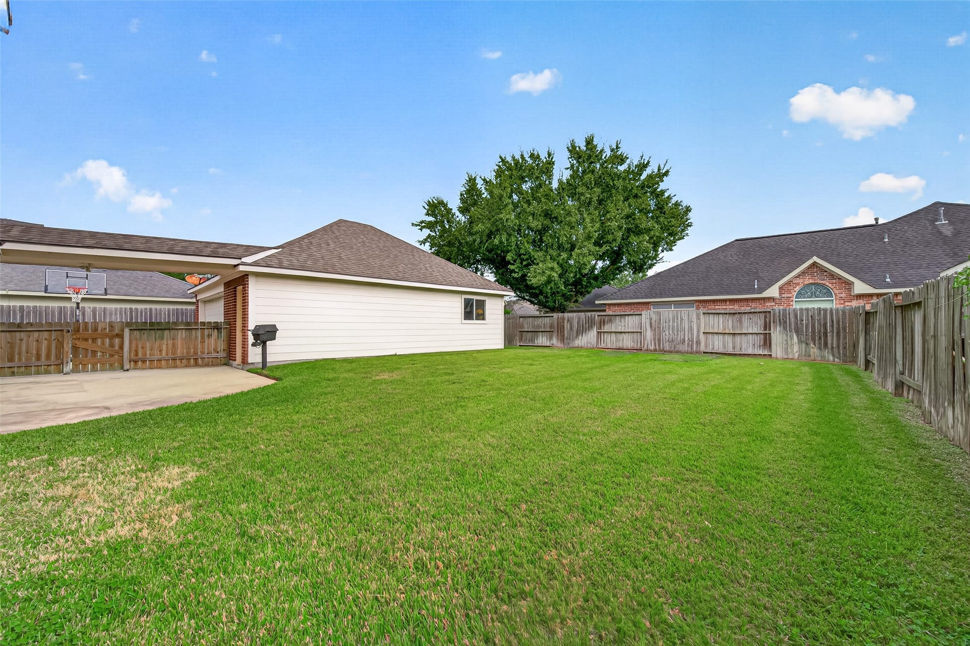 Backyard with lush green lawn perfect for outdoor activities, featuring a detached garage.