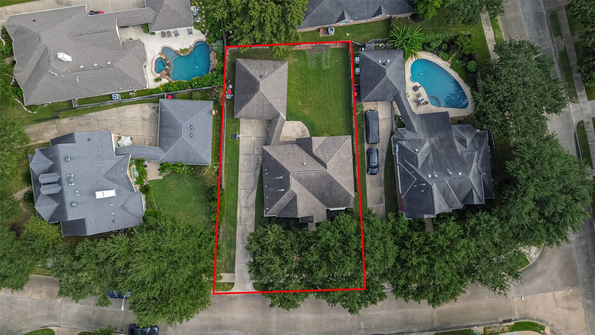 Spacious property highlighted by a large backyard, nestled in a serene neighborhood with nearby homes featuring pools and lush greenery.