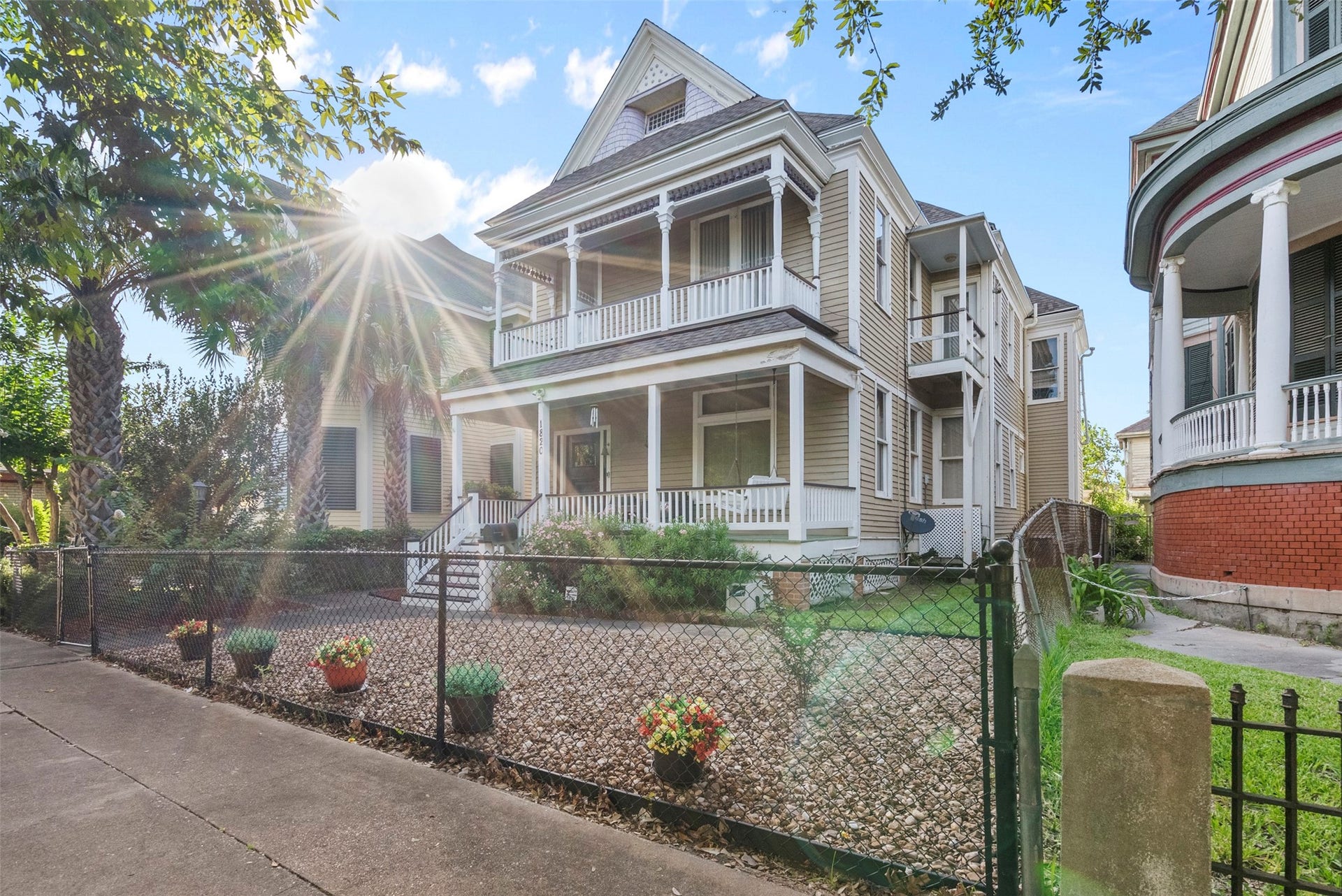 1820 Winnie Street, Galveston, TX 77550 Charming Victorian-style home with a welcoming front porch, nestled in a picturesque neighborhood. The exterior features elegant detailing, a well-maintained garden, and a fenced front yard, perfect for enjoying sunny days.