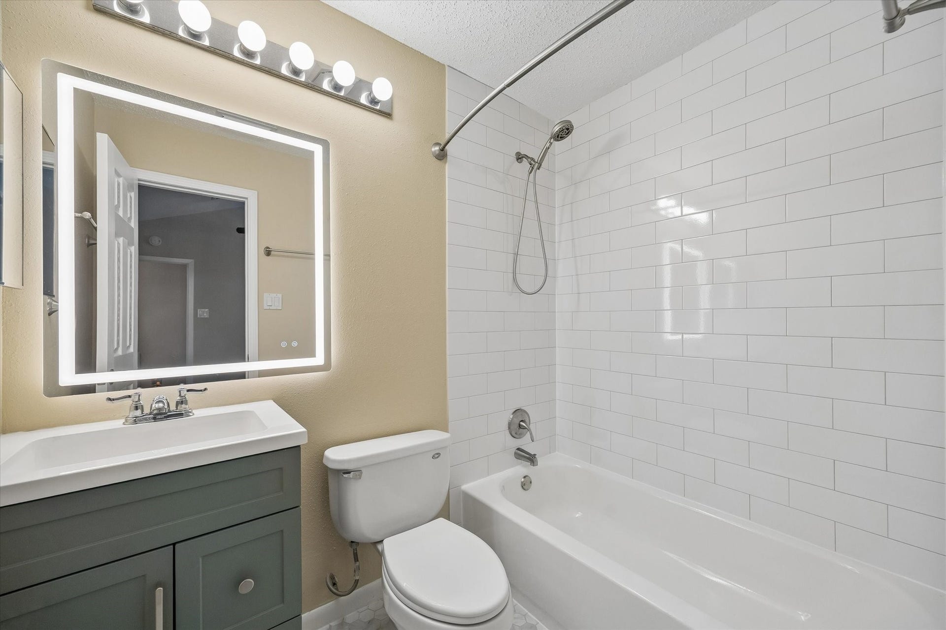 3911 Kitchen Hill Lane, Sugar Land, TX 77479 Start and end your day in this refreshed bathroom featuring a stylish green vanity, bright mirror, and classic subway tile.
