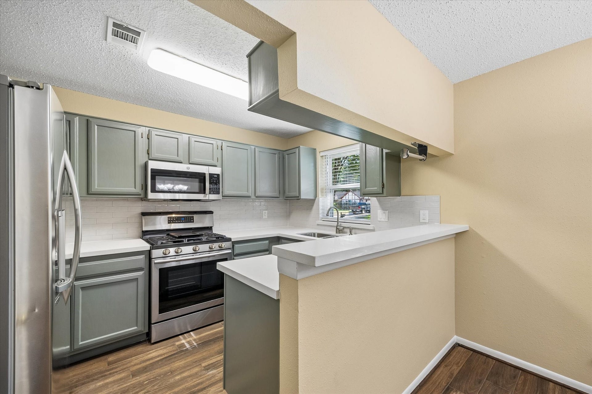 3911 Kitchen Hill Lane, Sugar Land, TX 77479 Love to cook? This updated kitchen features stylish sage-green cabinets, stainless steel appliances, and a convenient breakfast bar.