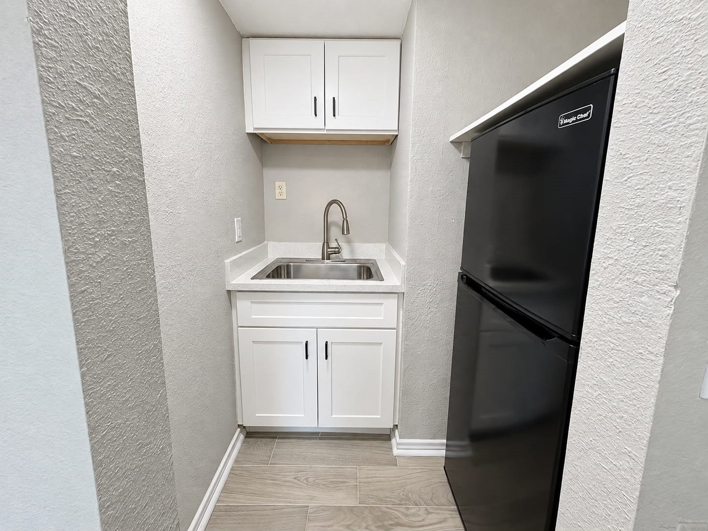9711 Linkmeadow Lane, #12B, Houston, TX 77025 Kitchenette with sink, cabinetry, and refrigerator.