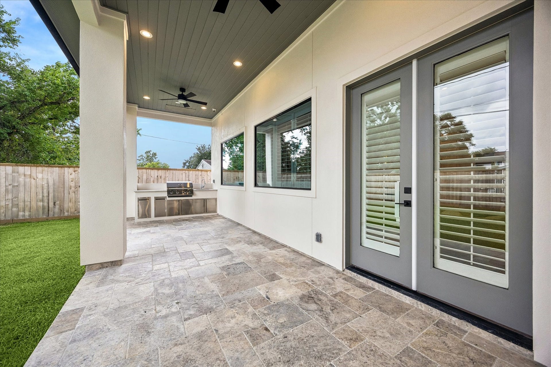 Covered outdoor living extends the home into the backyard with stone flooring, ceiling fans and a built in grilling station for easy outdoor entertaining.