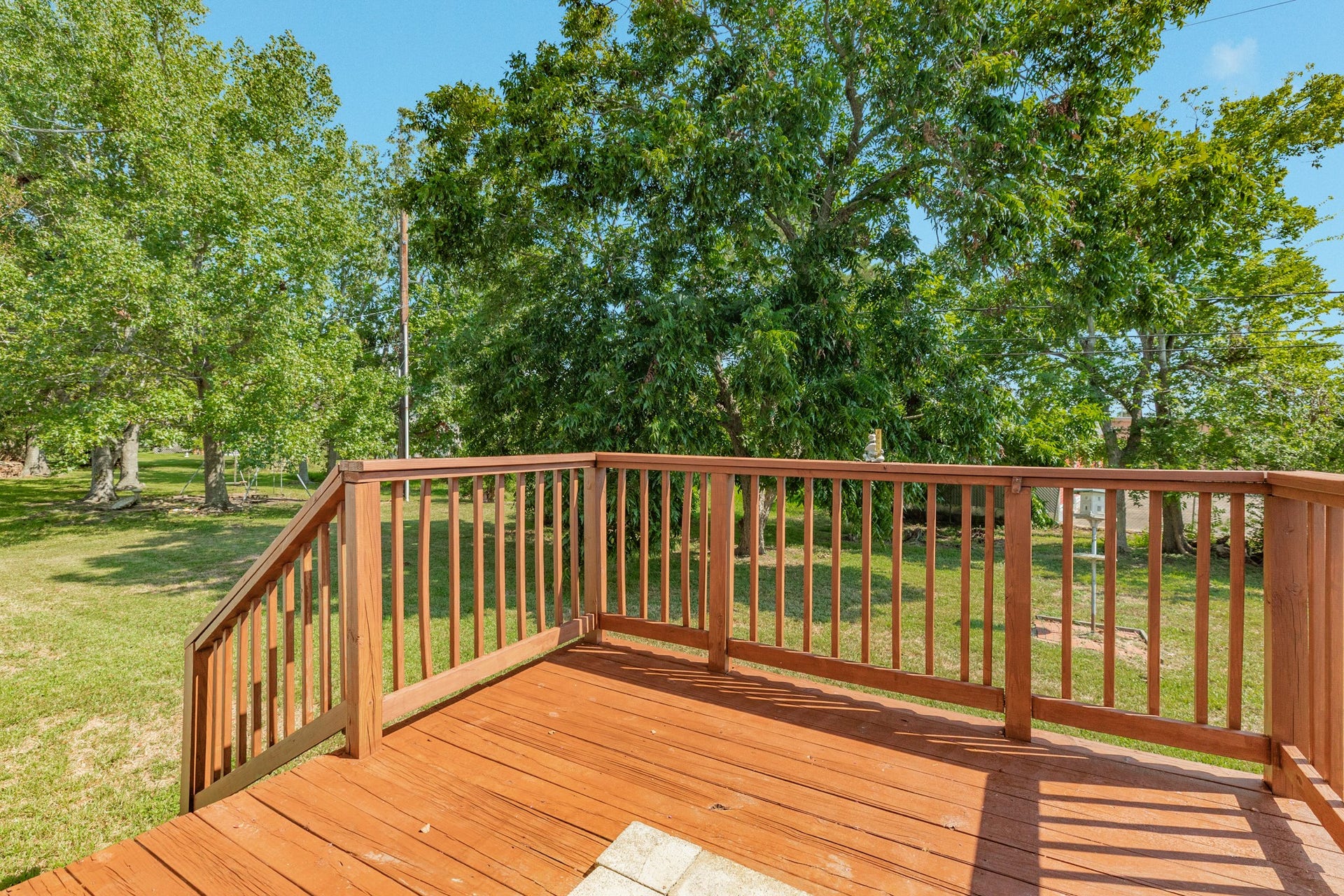 A raised wood deck with stairs overlooks the yard and creates a convenient outdoor gathering space directly accessible from the home.