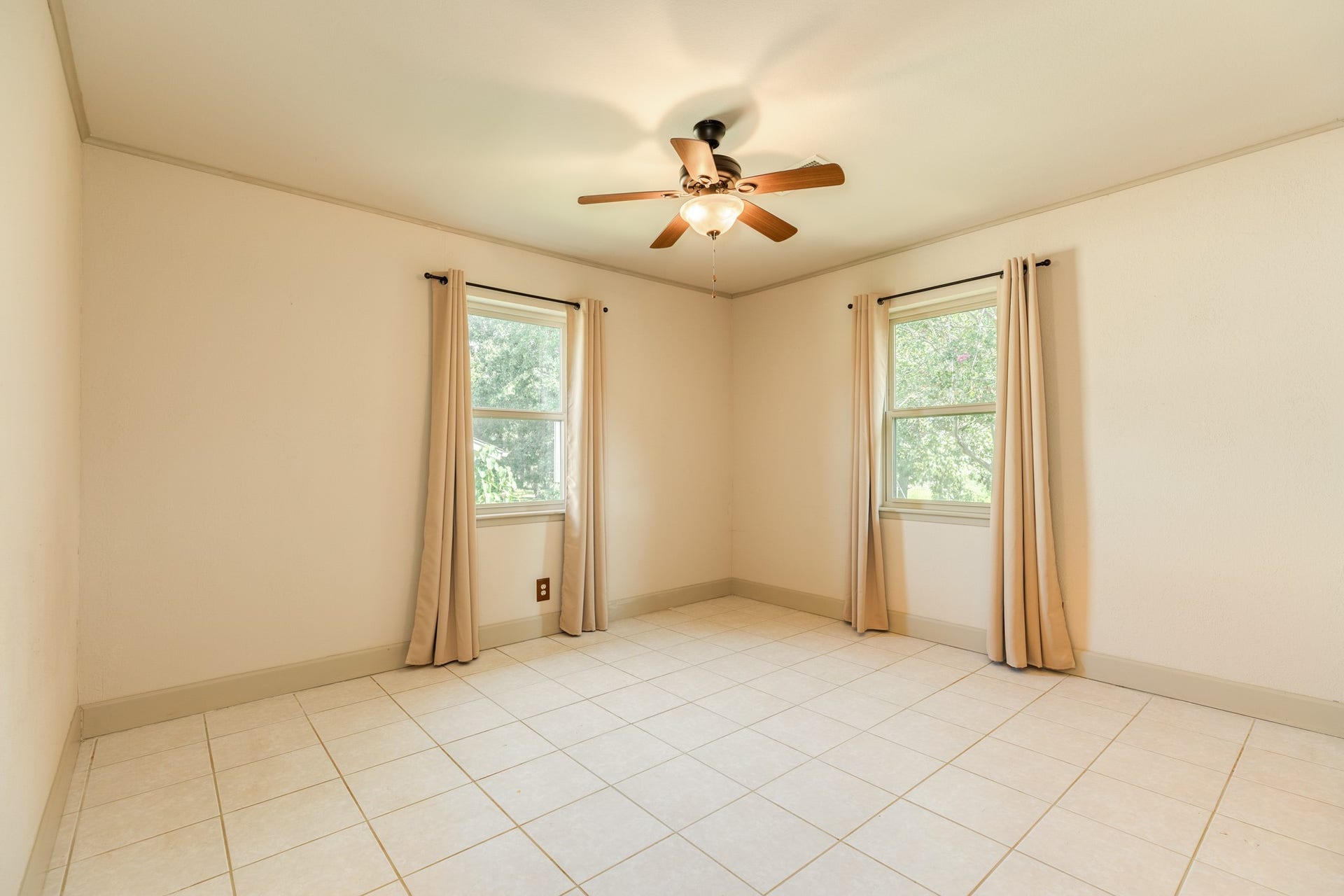 Comfortable bedrooms feature easy-care tile flooring, ceiling fans, and windows that provide plenty of natural light. Generously sized rooms offer flexibility for bedroom furniture, guest accommodations, a home office, or hobby space, with closet storage available in select rooms.