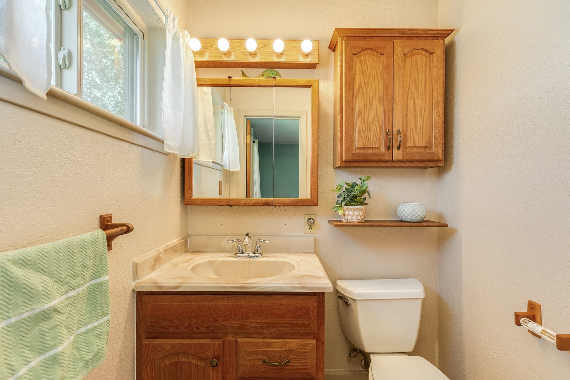 Primary bedroom feature easy-care tile flooring, ceiling fans, and windows that provide plenty of natural light with en-suite half bath and large walk-in closet.