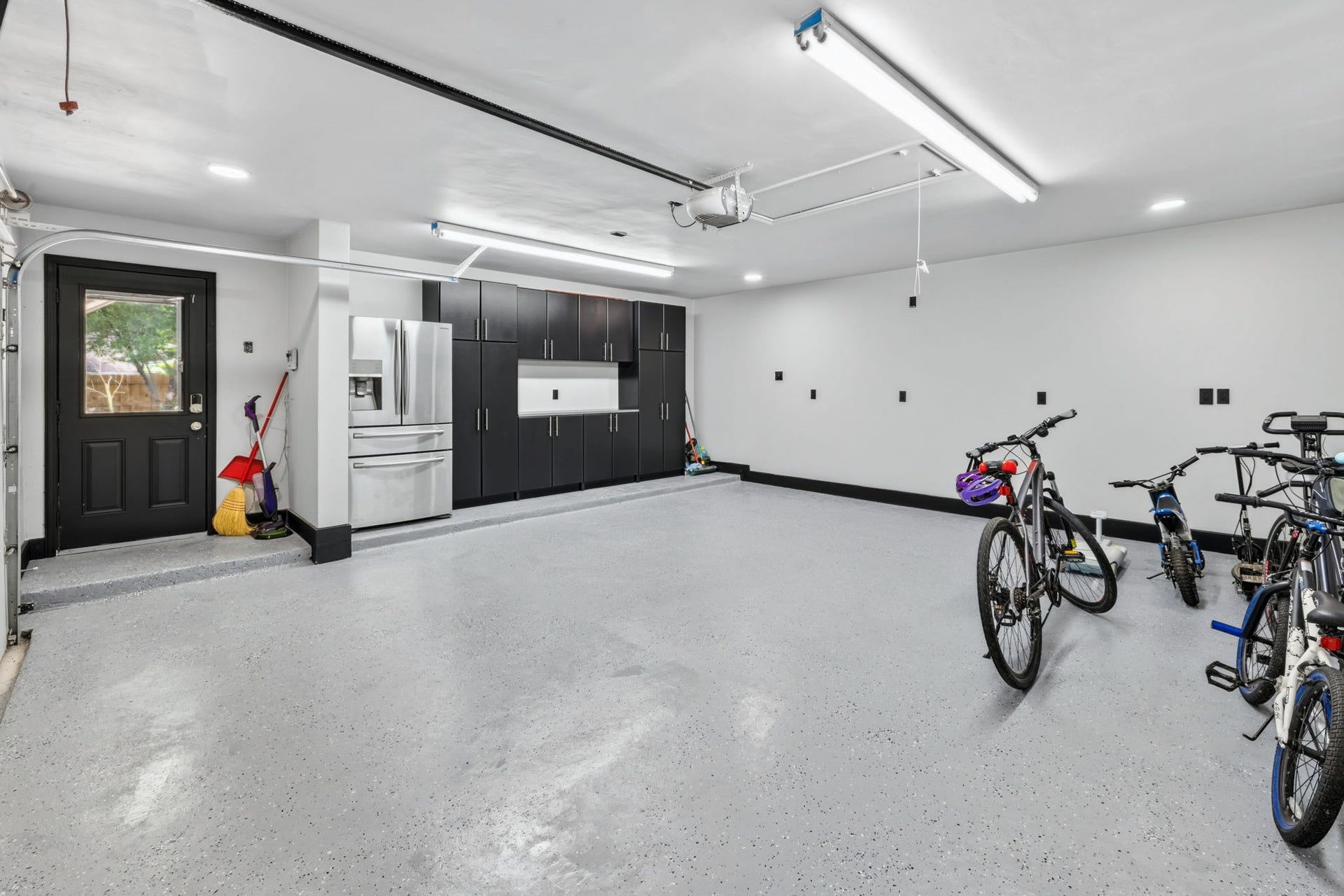 129 N Rainbow Ridge Circle, The Woodlands, TX 77381 Built-in storage, workspace counters, and a fridge create a garage that feels truly custom
