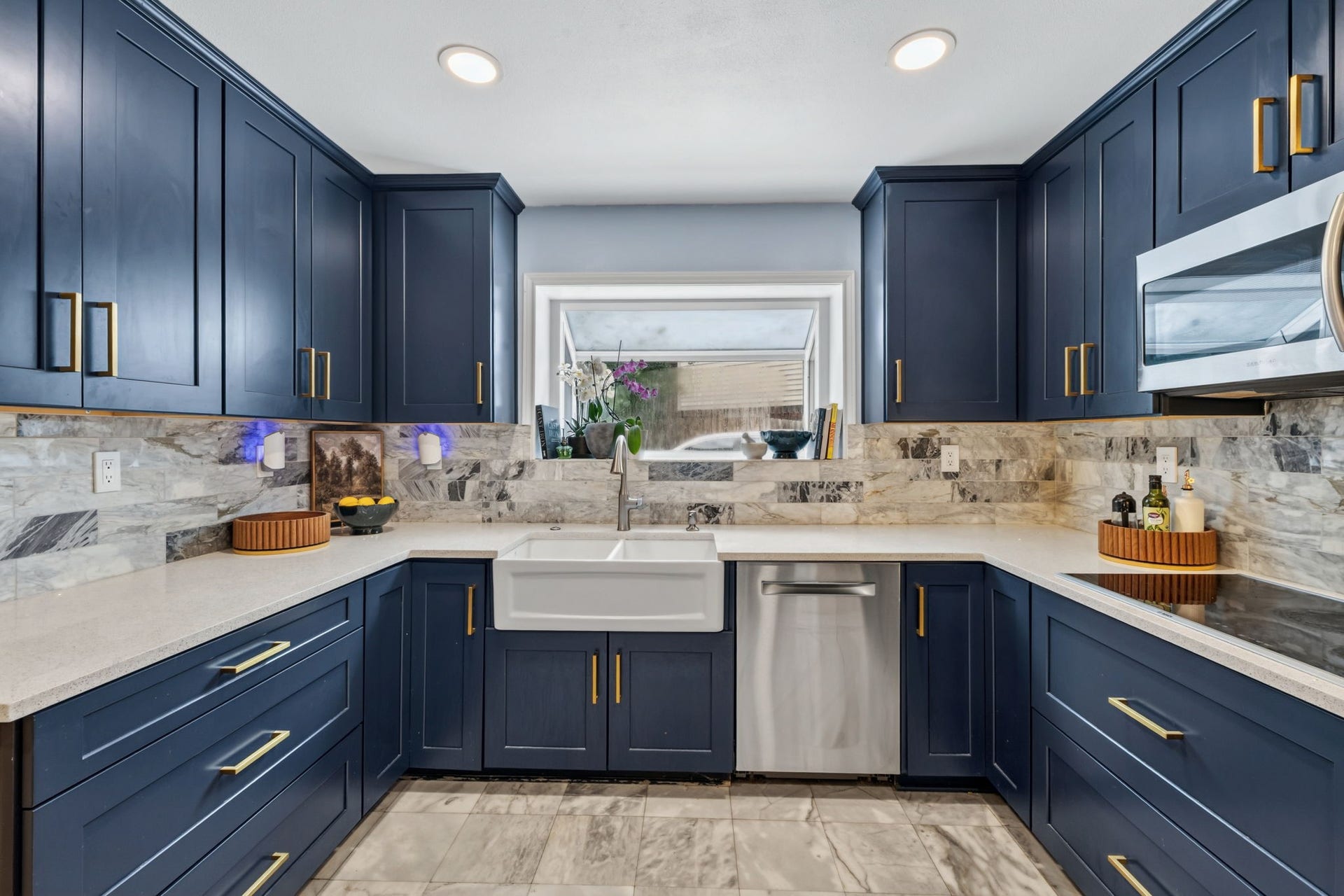 129 N Rainbow Ridge Circle, The Woodlands, TX 77381 A refreshed kitchen where bold blue cabinetry meets warm gold accents
