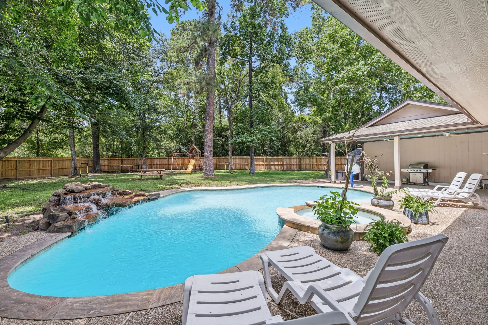 129 N Rainbow Ridge Circle, The Woodlands, TX 77381 Waterfall features bring movement, sound, and a sense of escape to the space
