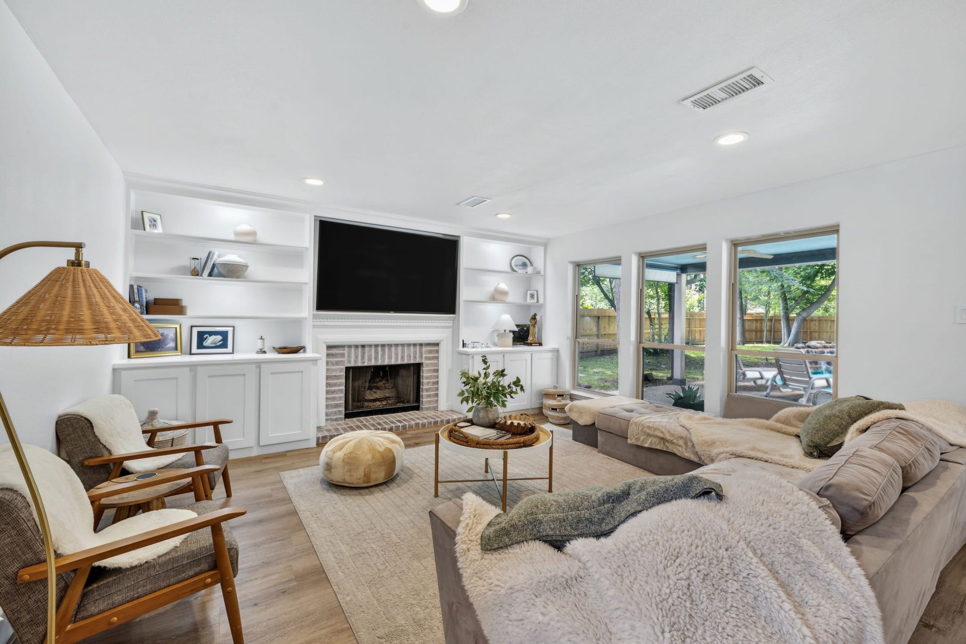 129 N Rainbow Ridge Circle, The Woodlands, TX 77381 Built-ins, fireplace warmth, and walls of windows create a cozy place to gather