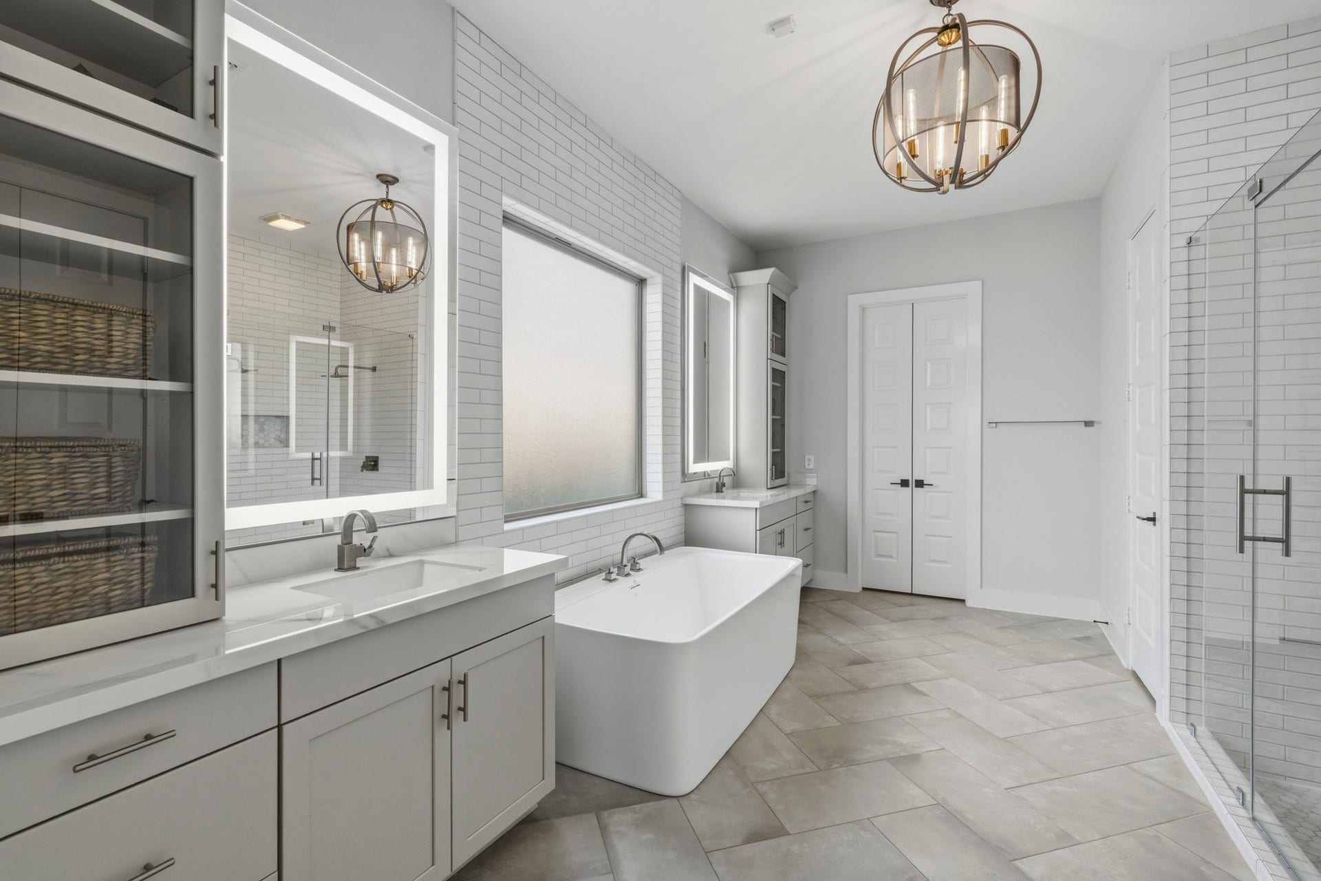 9907 Regal Bend Drive, Missouri City, TX 77459 Primary Bathroom with custom shaker cabinets with glass toppers, Porcelain counter-tops, floor to ceiling subway tile, marble mosaic floor, LED mirrors, Framless shower with 2 waterfall shower heads!