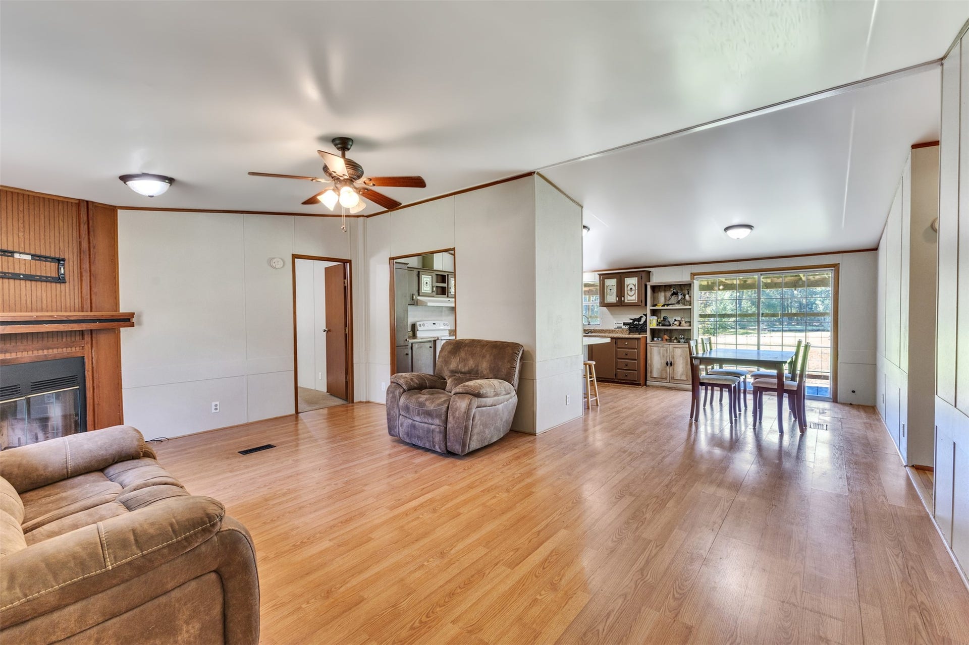 2009 Holder Rambo Road, Huffman, TX 77336 Spacious open-concept living area featuring hardwood floors, a cozy fireplace, and abundant natural light from large windows.