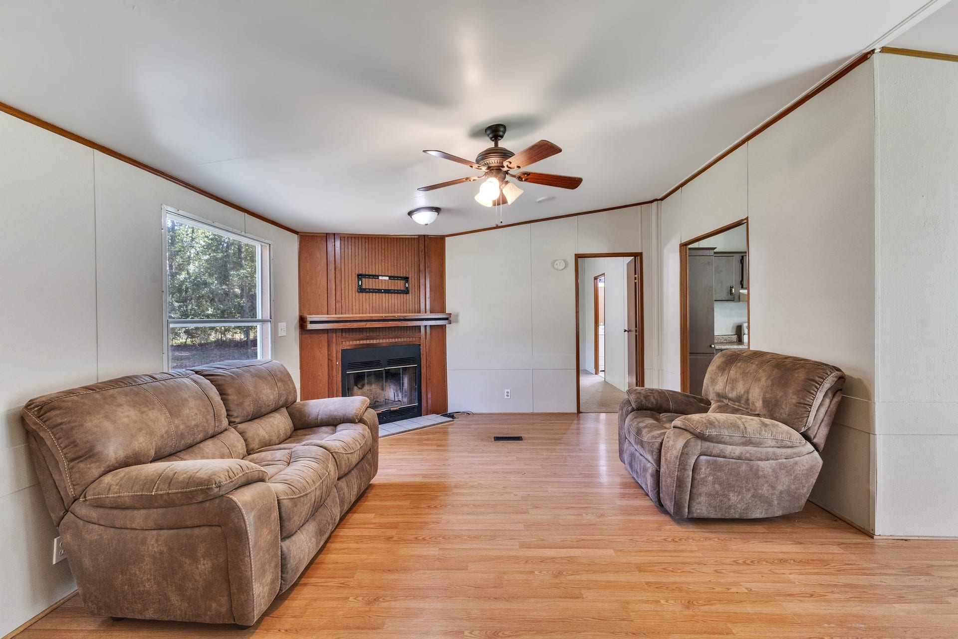 2009 Holder Rambo Road, Huffman, TX 77336 Spacious living room featuring warm wood flooring, a cozy fireplace, and comfortable seating, perfect for relaxing or entertaining.