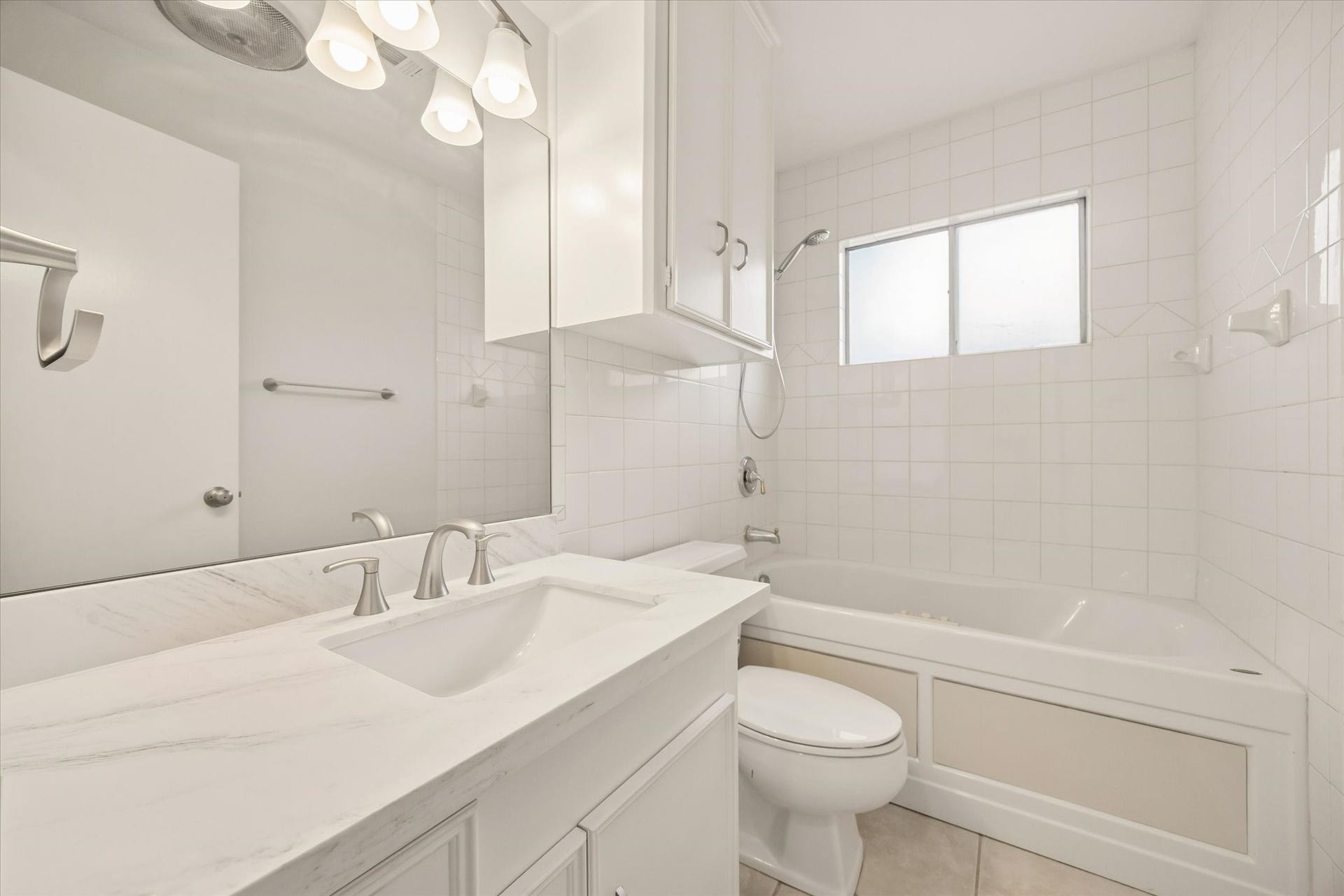 114 CAMELLIA STREET, Sugar Land, TX 77478 THE FULL BATH FEATURES A STONE-TOPPED VANITY, UNDERMOUNT SINK, AMPLE STORAGE, AND A TUB-SHOWER COMBINATION WITH TILE SURROUND.