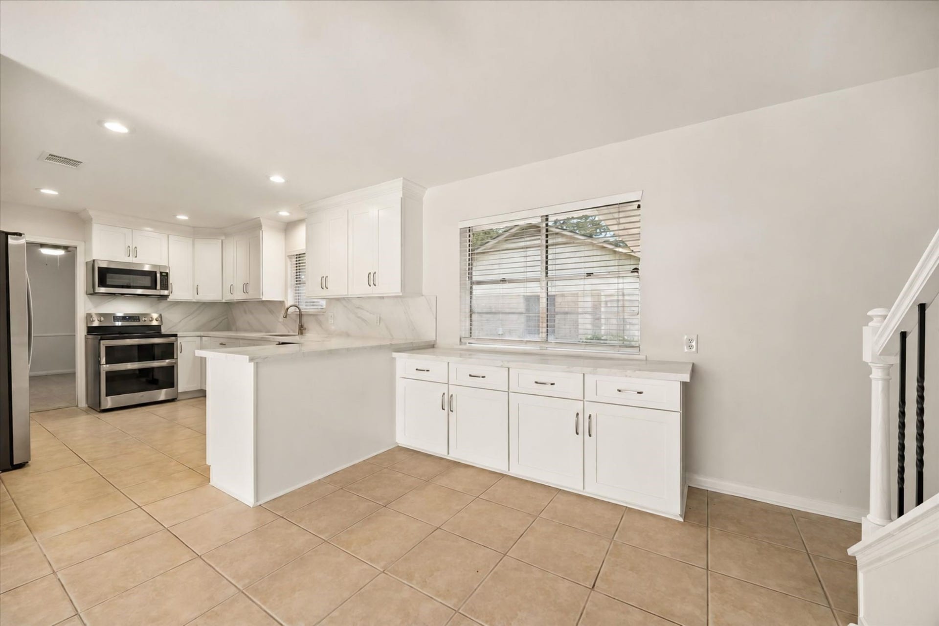 114 CAMELLIA STREET, Sugar Land, TX 77478 THE UPDATED KITCHEN FEATURES WHITE CABINETRY, GENEROUS STORAGE, EXTENDED COUNTER SPACE, RECESSED LIGHTING, AND A CONVENIENT BREAKFAST BAR.