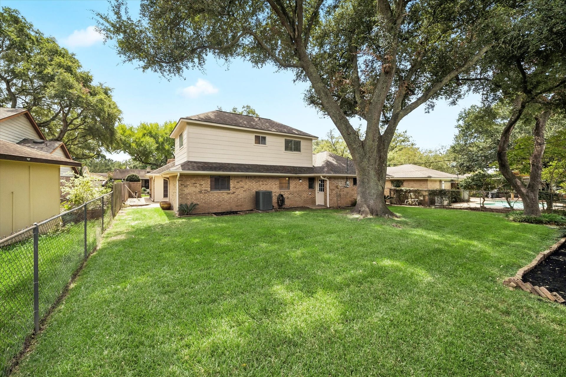 114 CAMELLIA STREET, Sugar Land, TX 77478 THE SPACIOUS BACKYARD OFFERS A LARGE LAWN, MATURE SHADE TREES, AND PLENTY OF ROOM FOR OUTDOOR LIVING OR PLAY.
