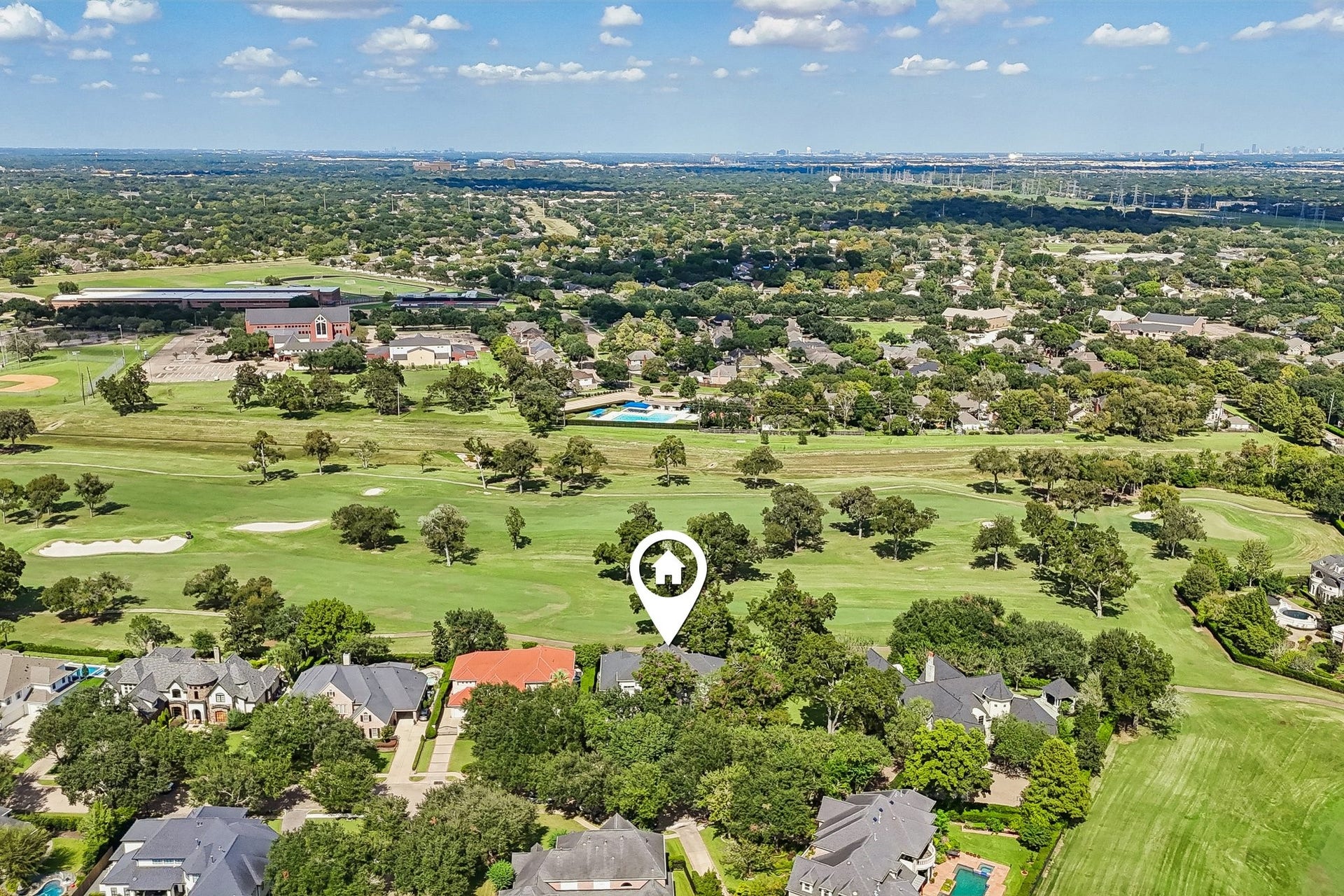 Aerial view showcasing the homes premier setting along the TPC Houston golf course, surrounded by manicured fairways, mature trees, and lush green space