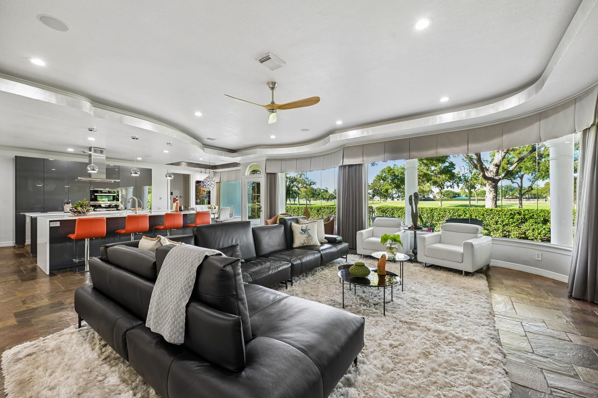 Light-filled living area with a curved ceiling, generous seating space, and an open connection to the chef-inspired kitchen