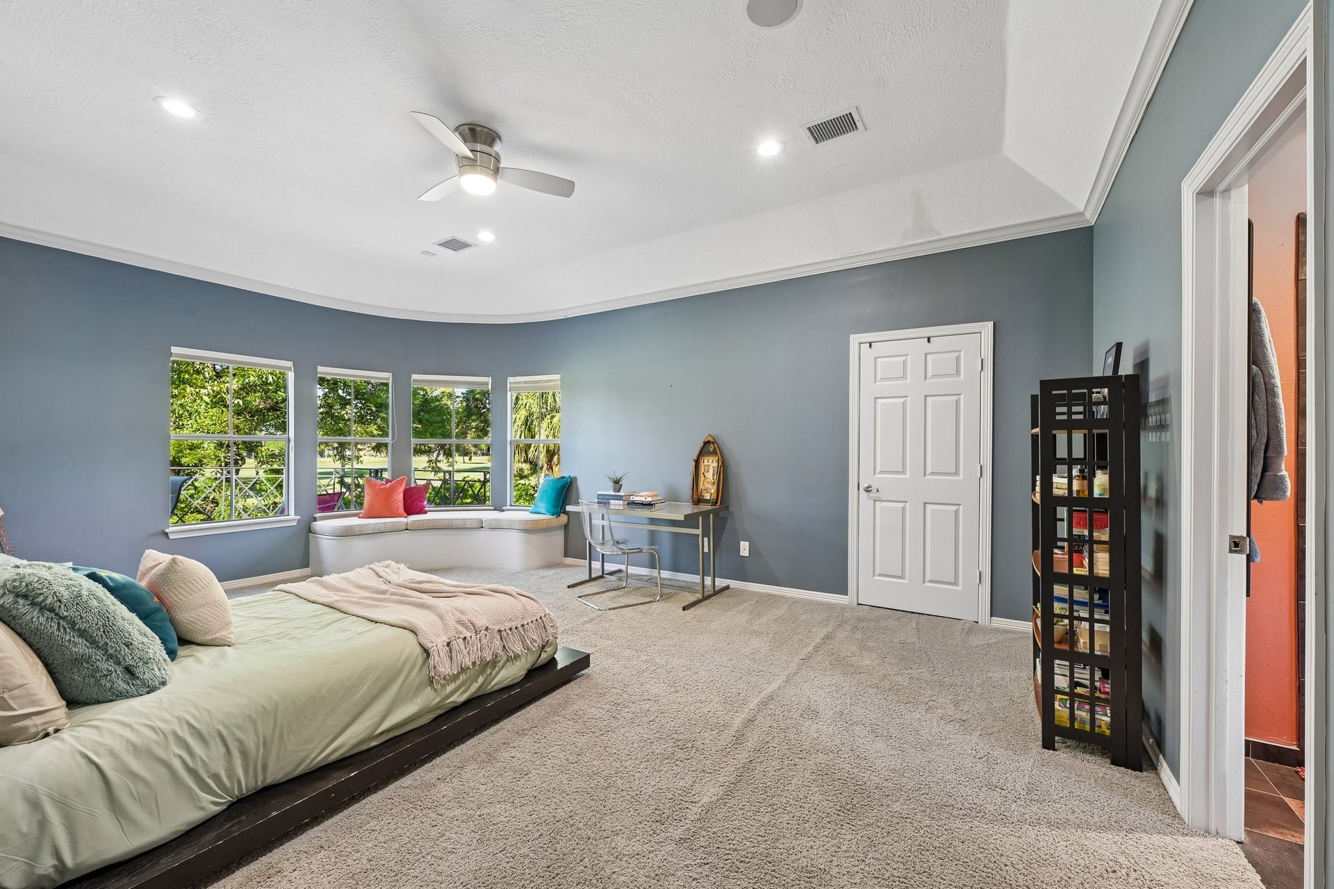 Secondary bedroom featuring a spacious layout, a charming window-side sitting nook, and an adjoining bathroom shared with the neighboring bedroom